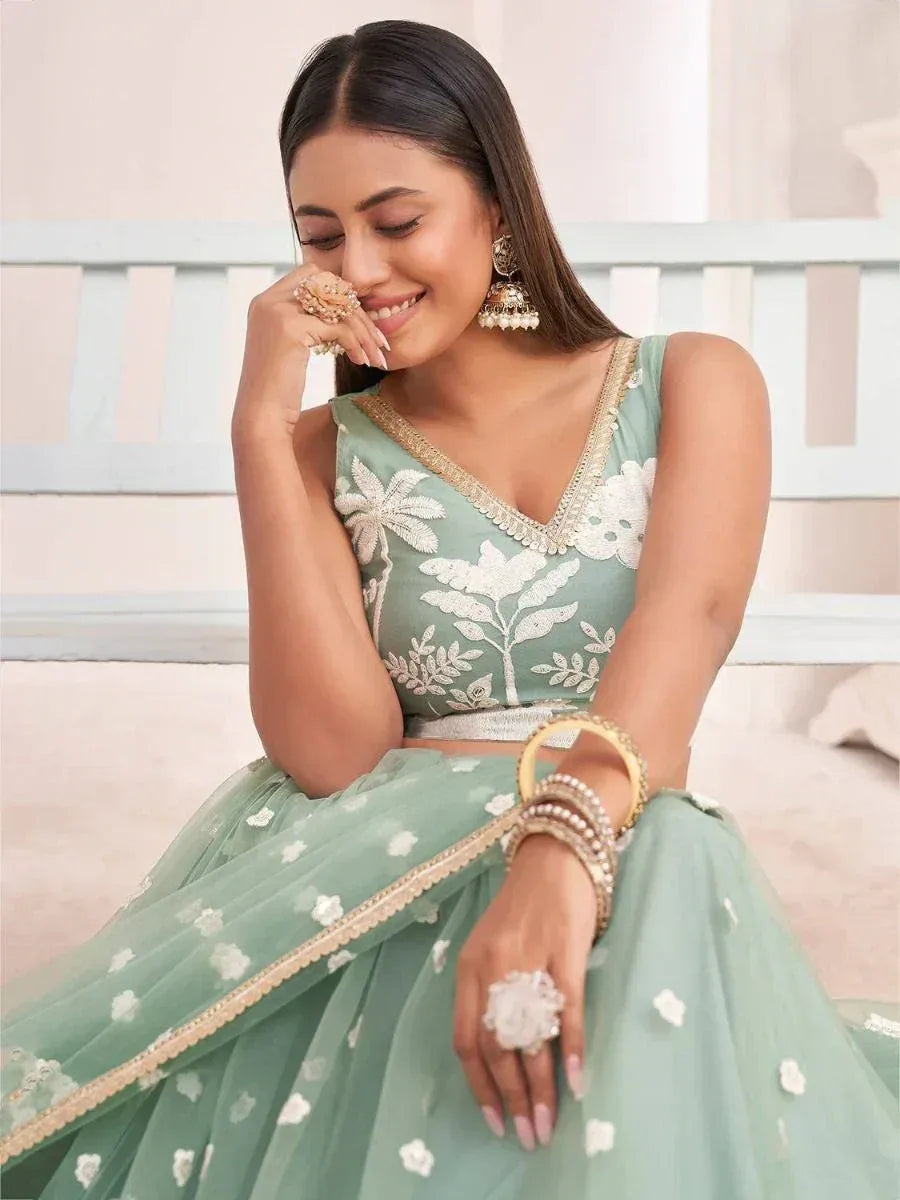 Mint green designer lehenga choli with white floral embroidery and gold trim, perfect for Indian ethnic wear.