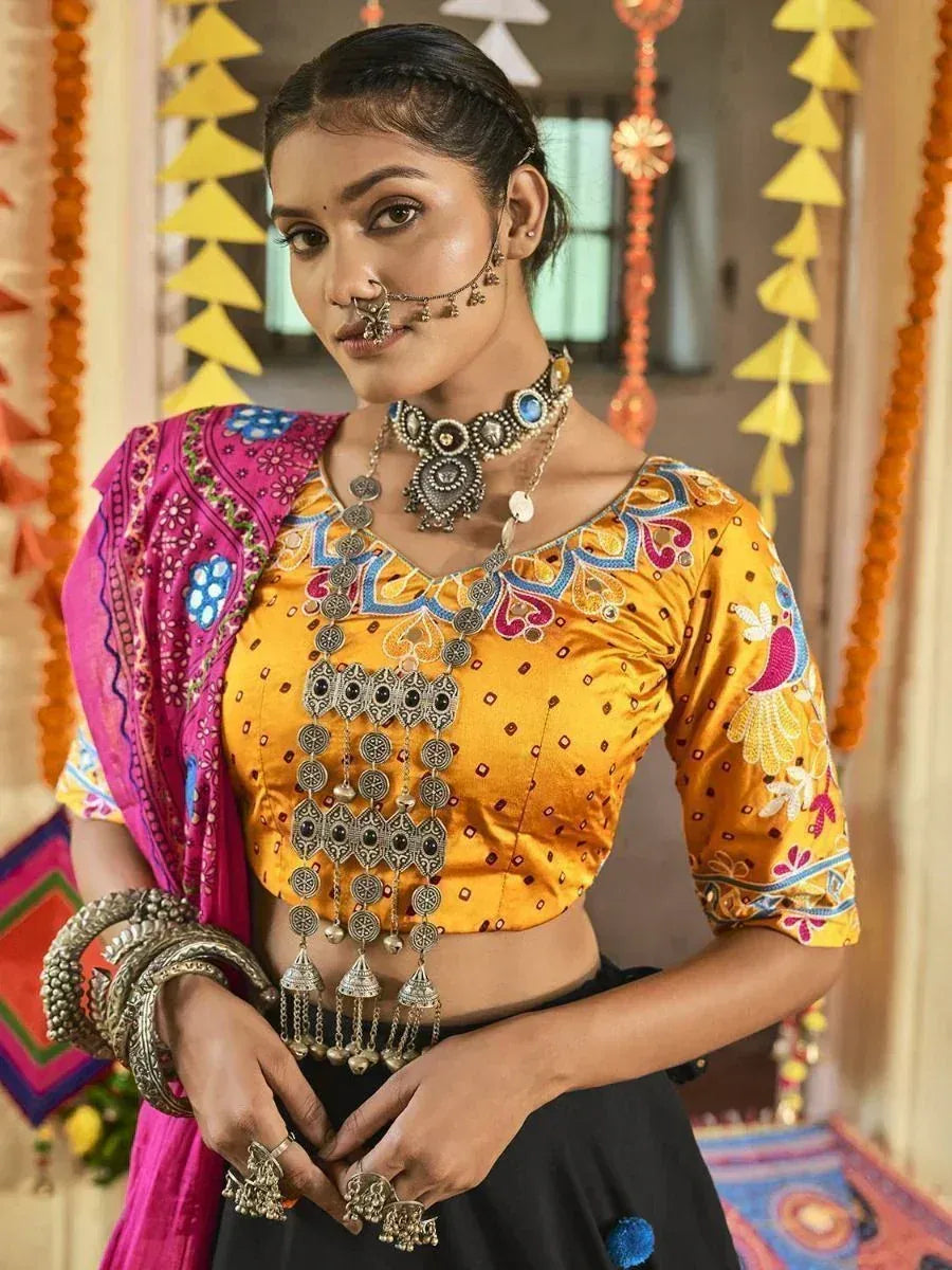 Woman in vibrant yellow embroidered blouse with pink dupatta, traditional Indian jewelry, festive decor