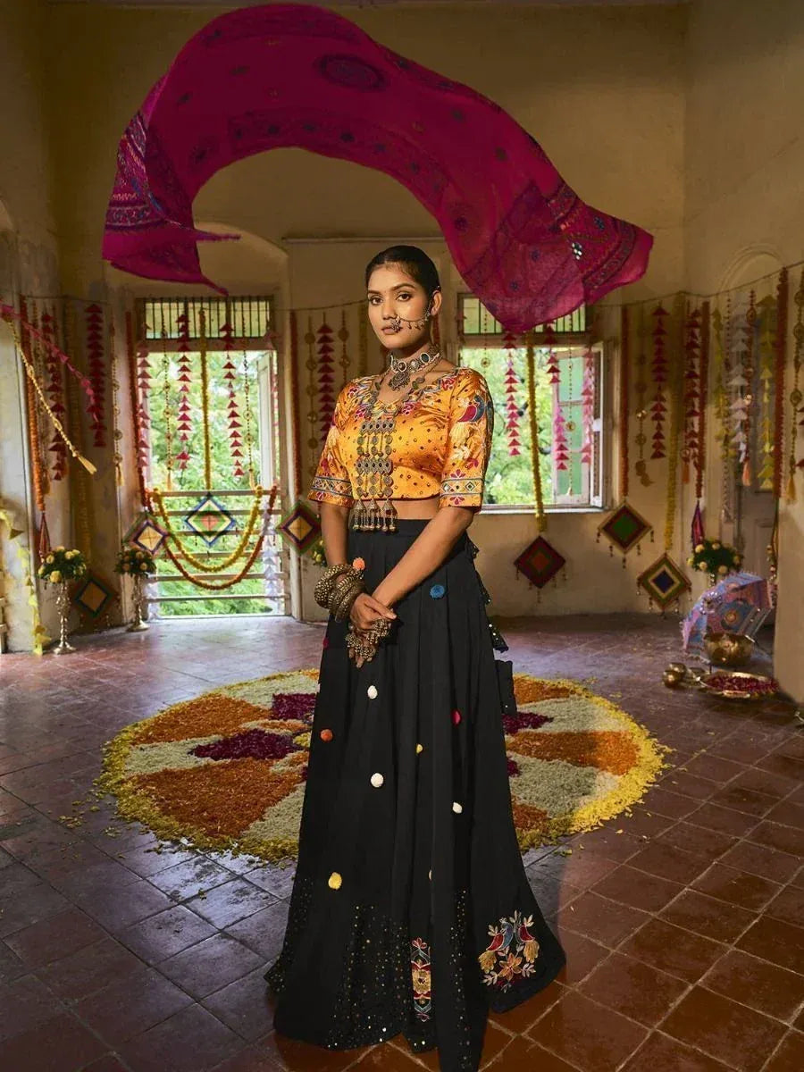 Woman in designer lehenga choli with embroidered black skirt and yellow blouse, festive Indian ethnic wear