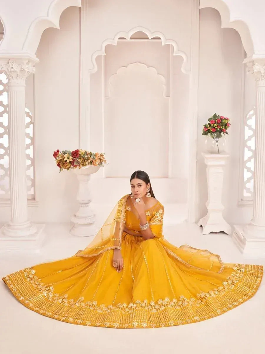 Yellow designer lehenga choli with gold embroidery, perfect for Indian weddings and festive occasions.