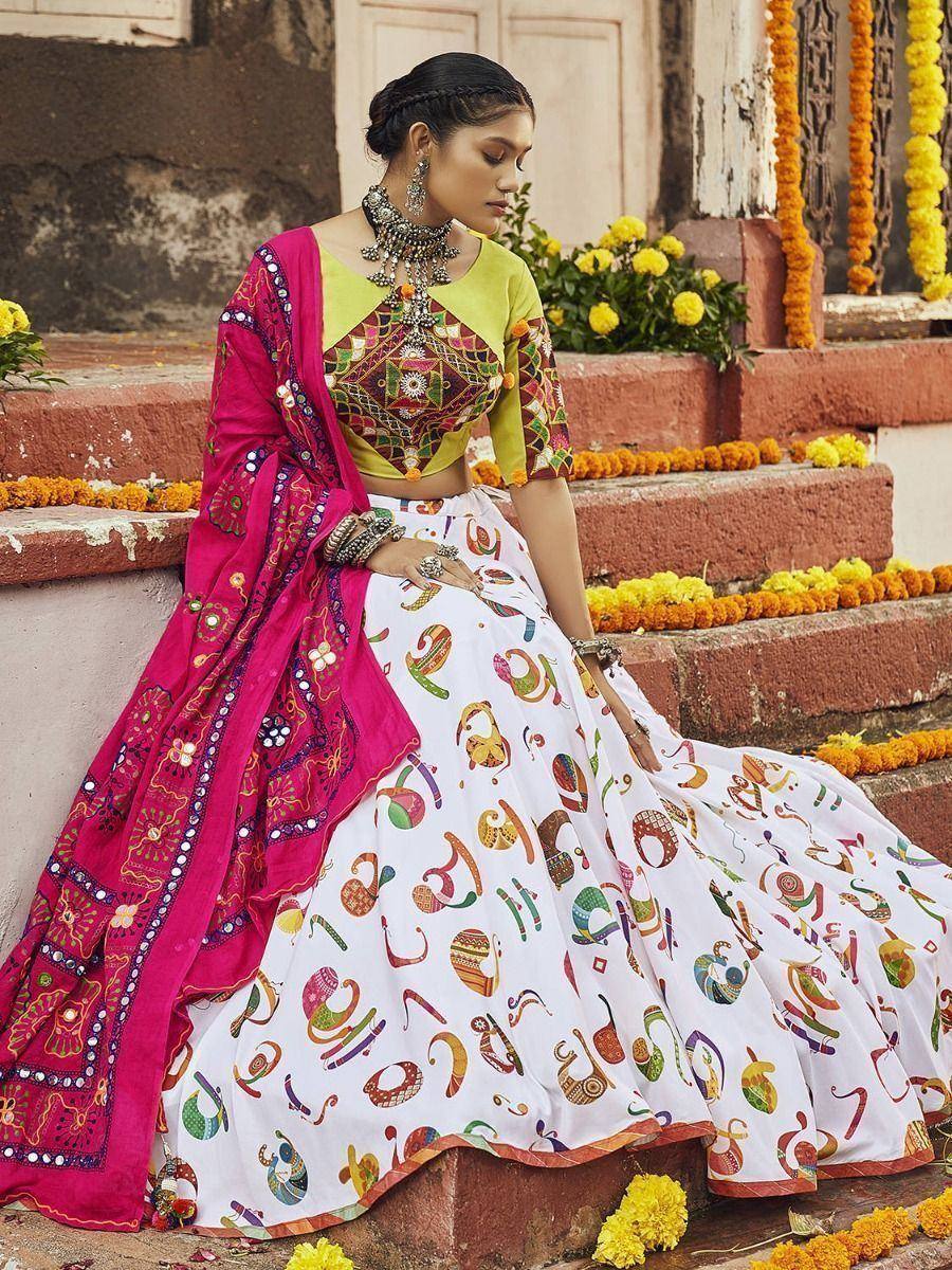 Woman in colorful printed lehenga choli with pink dupatta, traditional Indian ethnic wear for festive occasions