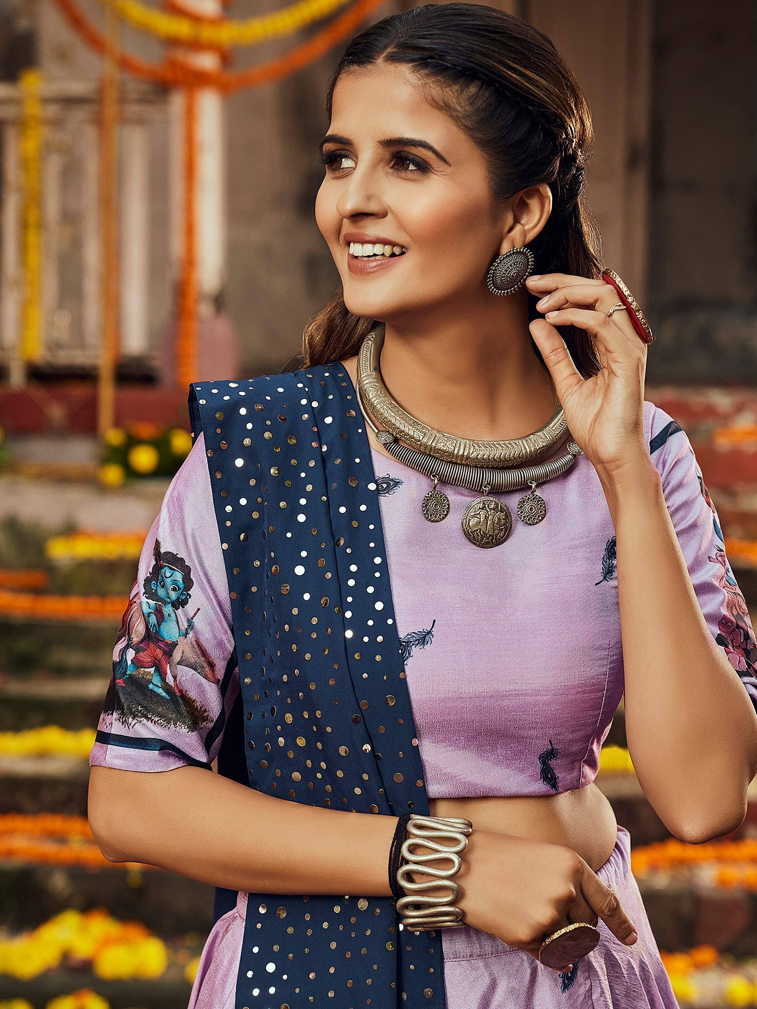 Woman in purple printed ethnic top with navy polka dot dupatta, tribal jewelry, festive backdrop