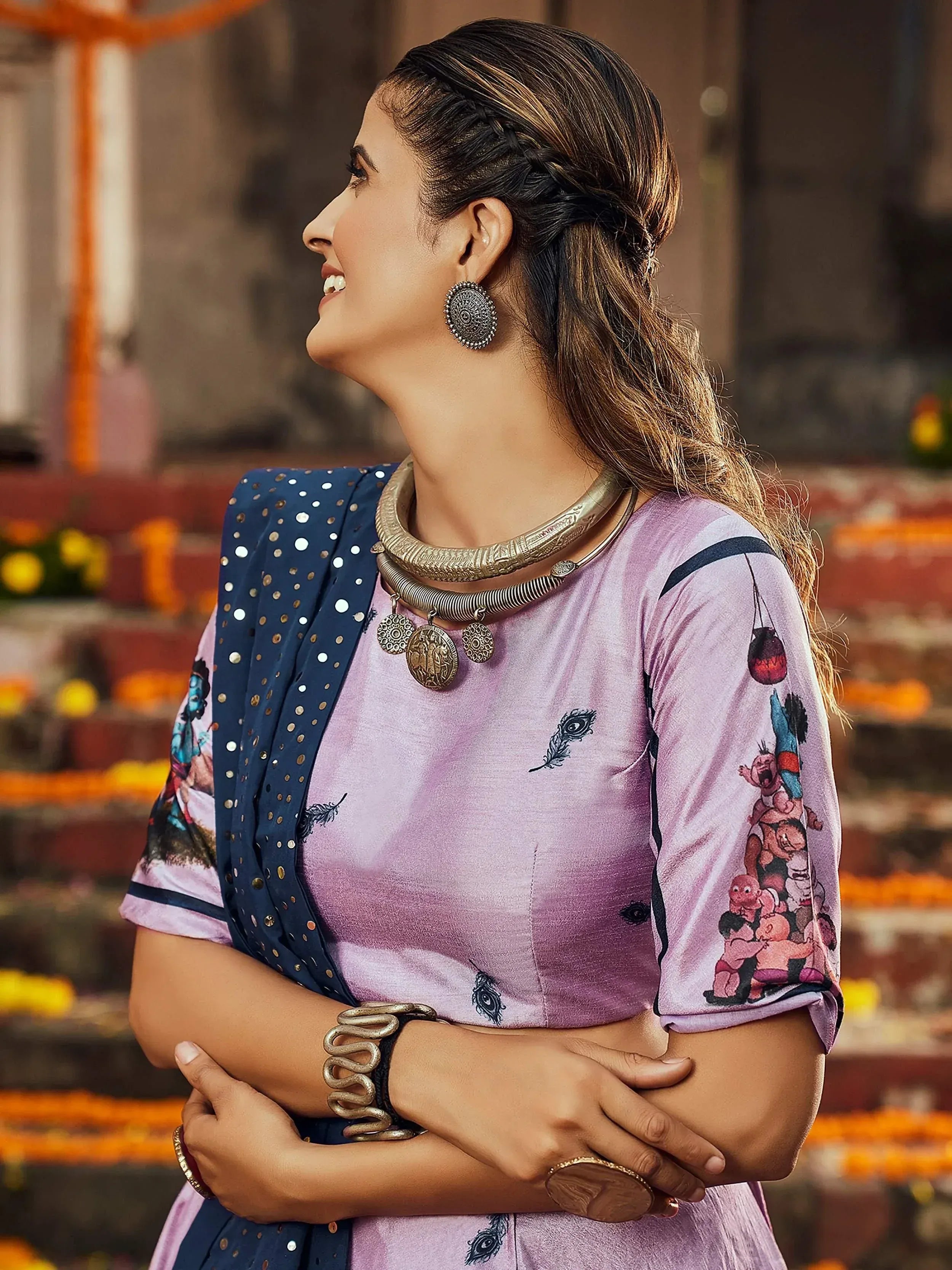 Woman in purple printed kurta with navy blue dupatta, ethnic jewelry, and festive temple backdrop