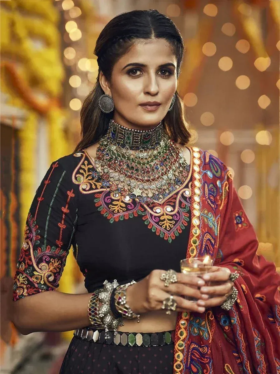 Woman in embroidered black choli with colorful dupatta, traditional Indian ethnic wear, festive jewelry