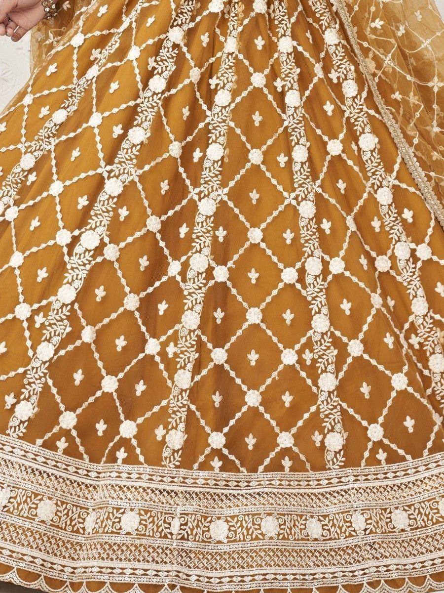 Mustard yellow lehenga with intricate white floral embroidery and geometric patterns, perfect for ethnic occasions.