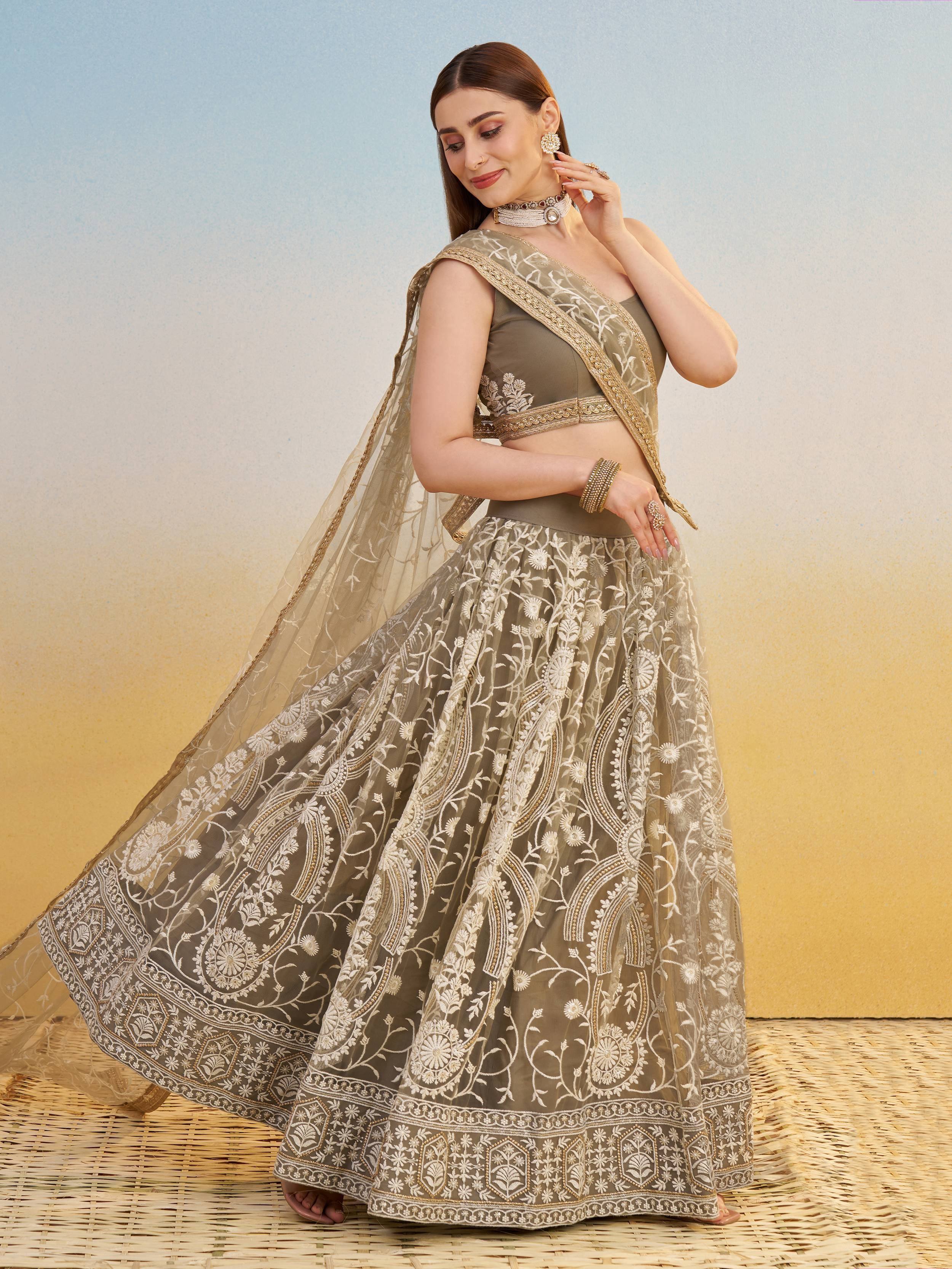 Elegant olive green lehenga choli with intricate white and gold embroidery, perfect for Indian ethnic wear occasions.