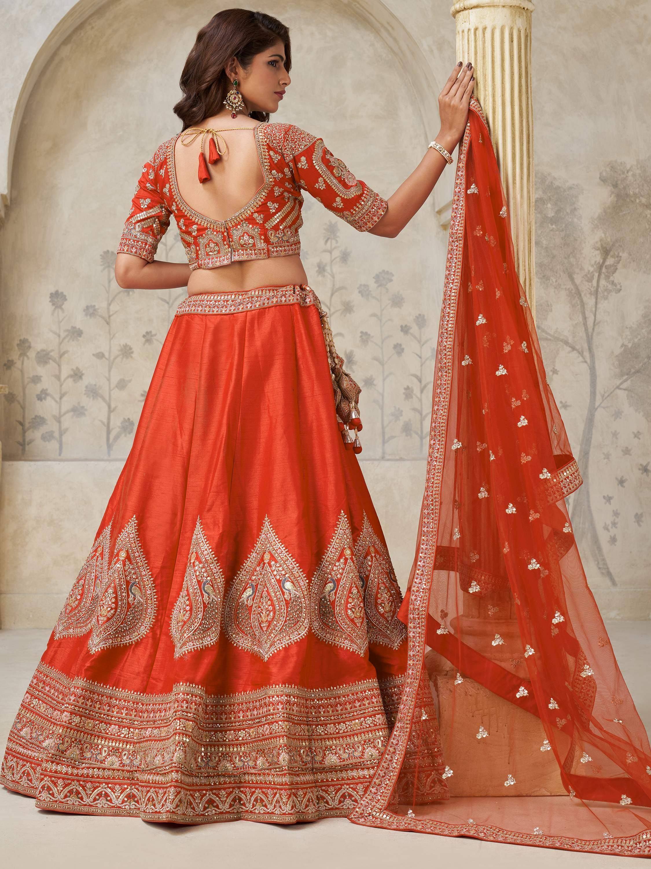 Orange embroidered lehenga choli with gold detailing, perfect for Indian weddings and festive occasions.