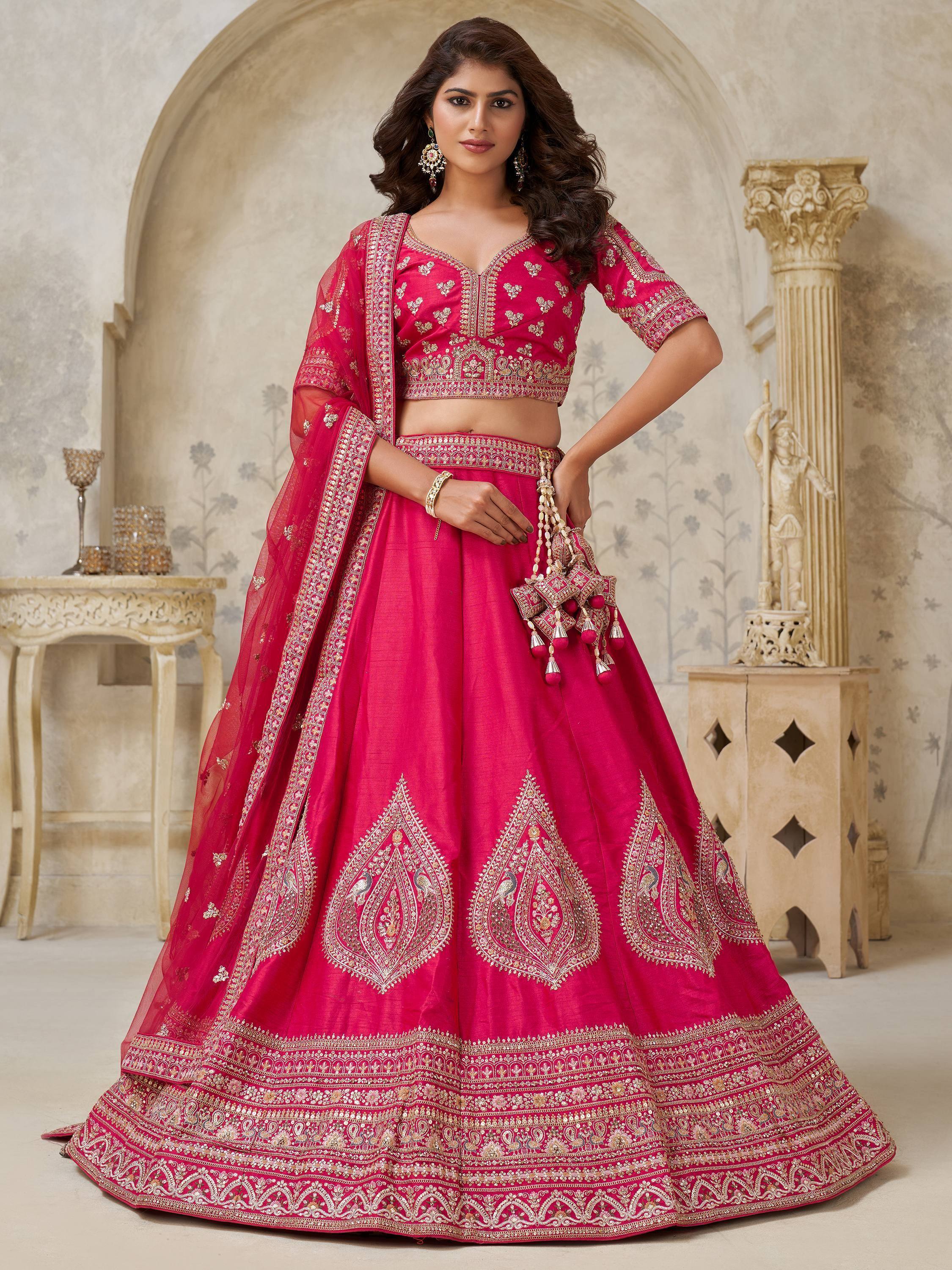 Fuchsia designer lehenga choli with gold embroidery, perfect for Indian weddings and festive occasions.