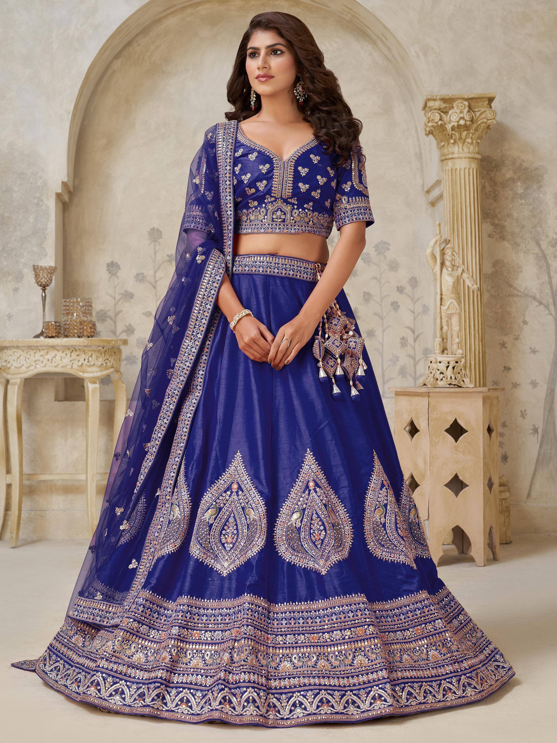Royal blue embroidered lehenga choli with peacock motifs, perfect for Indian weddings and festive occasions.