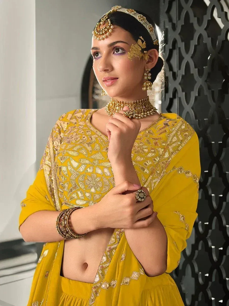 Yellow embroidered lehenga choli with gold jewelry, perfect for Indian ethnic wear and festive occasions.