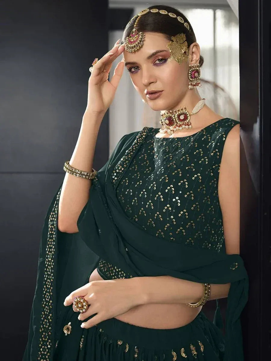 Emerald green sequined lehenga choli with gold embroidery and traditional Indian jewelry