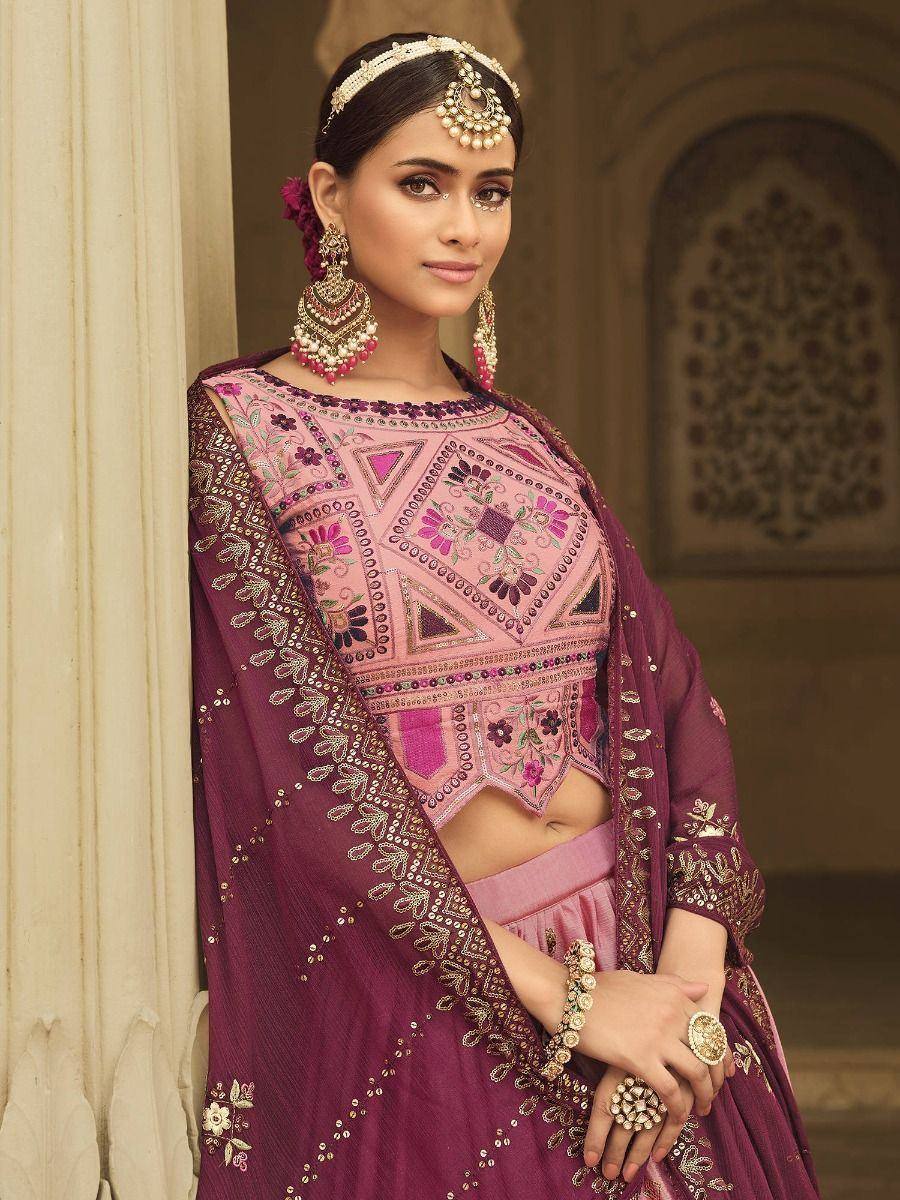 Pink and maroon embroidered lehenga choli with heavy jewelry, perfect for Indian weddings or festive occasions.