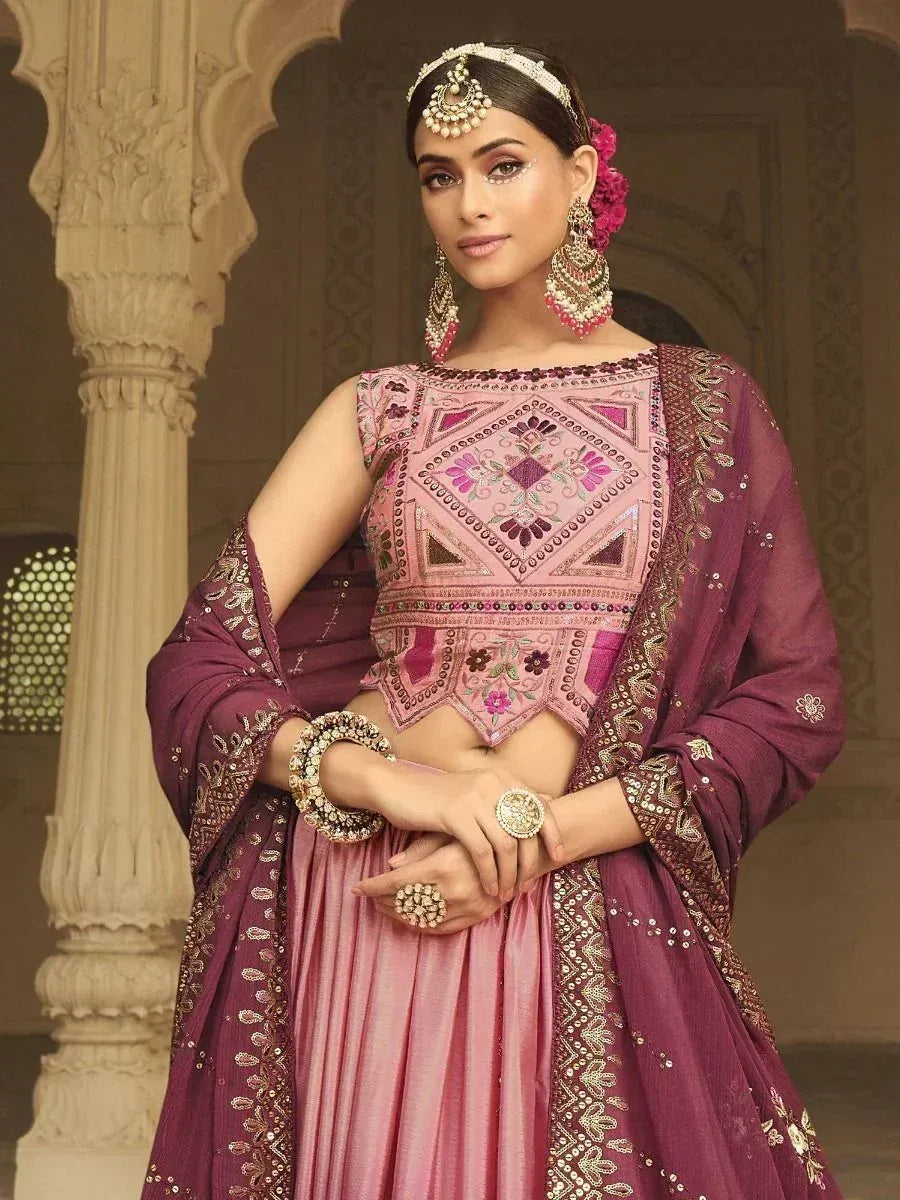Elegant pink and maroon embroidered lehenga choli with heavy jewelry, perfect for Indian weddings and festive occasions.