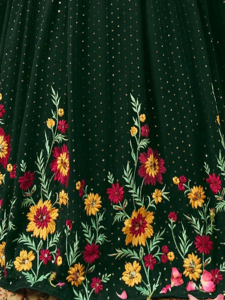 Dark green ethnic gown with vibrant floral embroidery and sequin detailing, perfect for festive occasions.