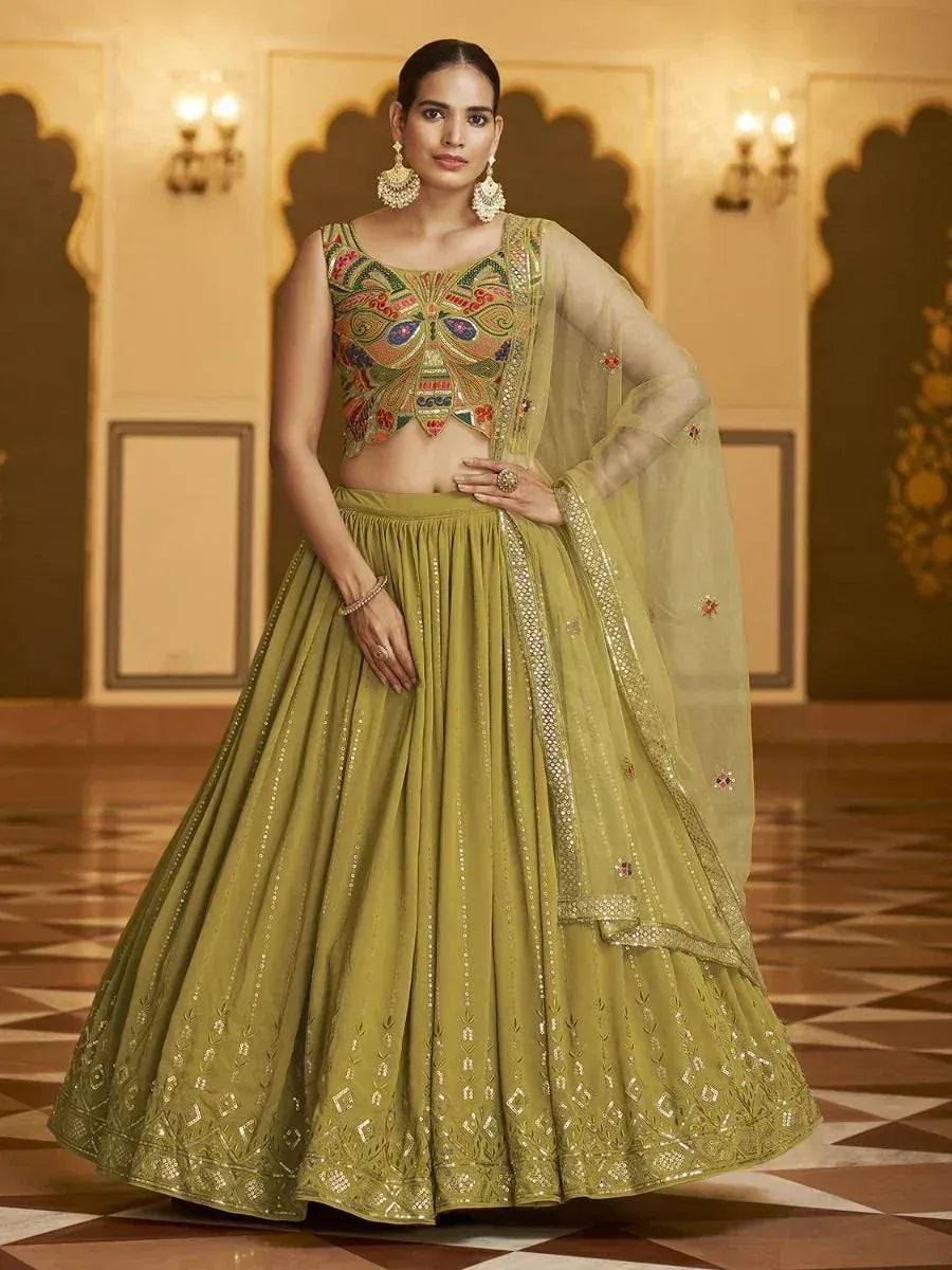 Olive green designer lehenga choli with heavy embroidery and sheer dupatta, perfect for Indian weddings and festivals.