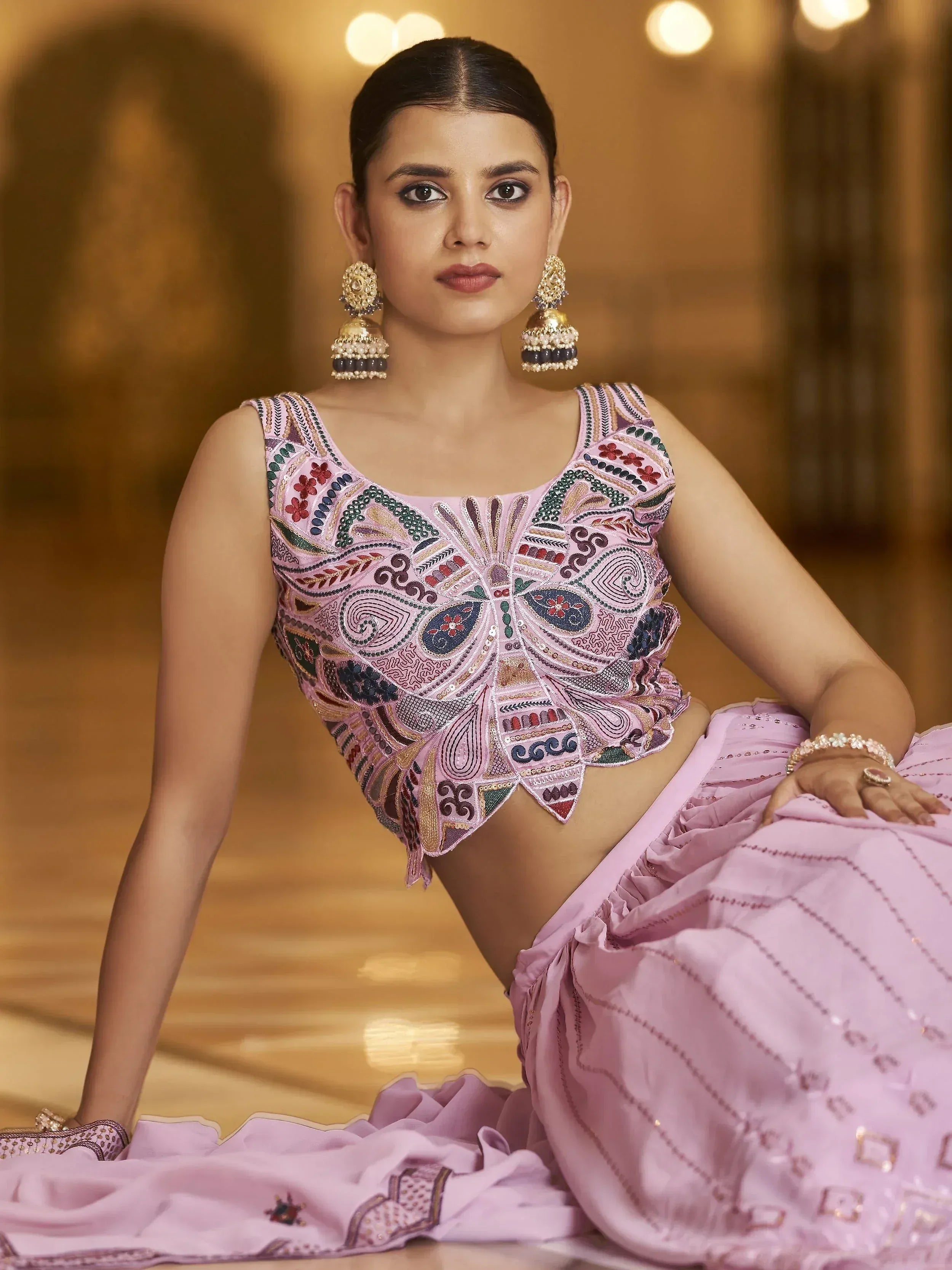 Woman in pink embroidered lehenga choli with floral motifs and jhumka earrings, Indian ethnic wear