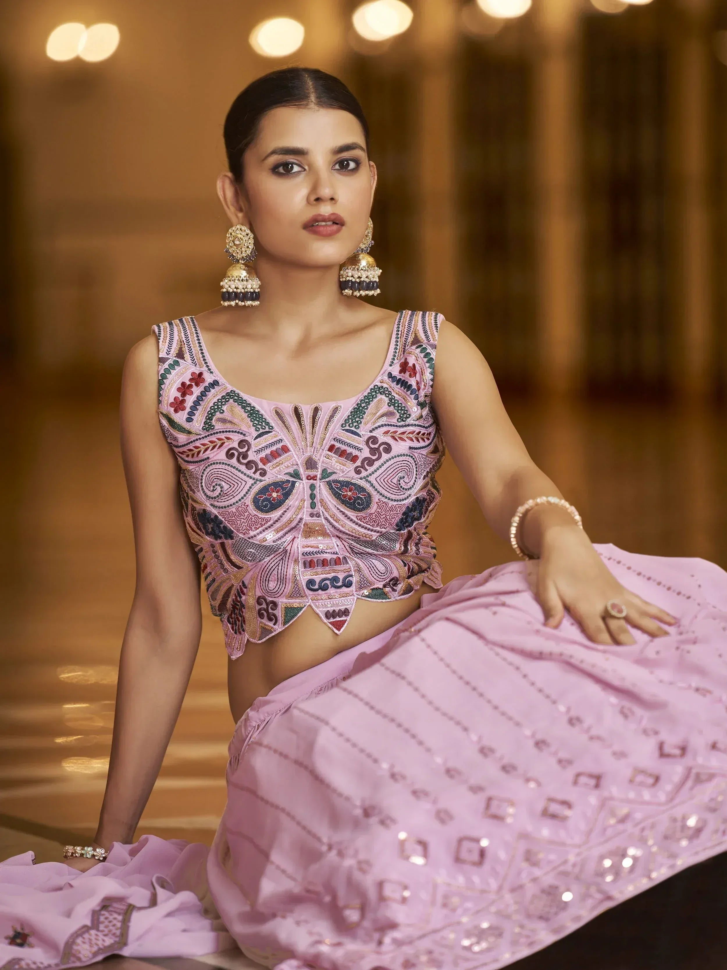 Woman in pink embroidered lehenga choli with statement earrings, Indian ethnic wear
