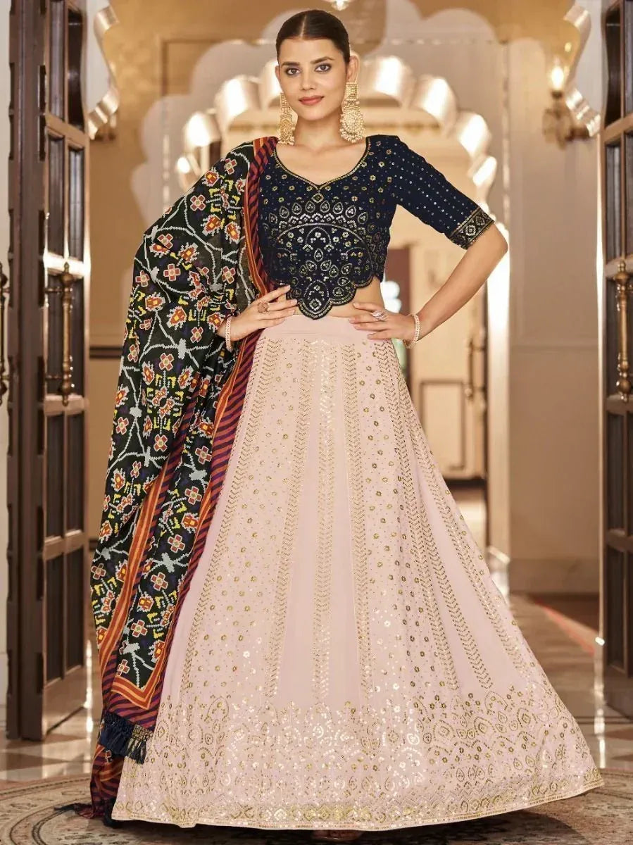 Elegant Indian lehenga choli with embroidered navy blouse and blush pink skirt, paired with floral dupatta