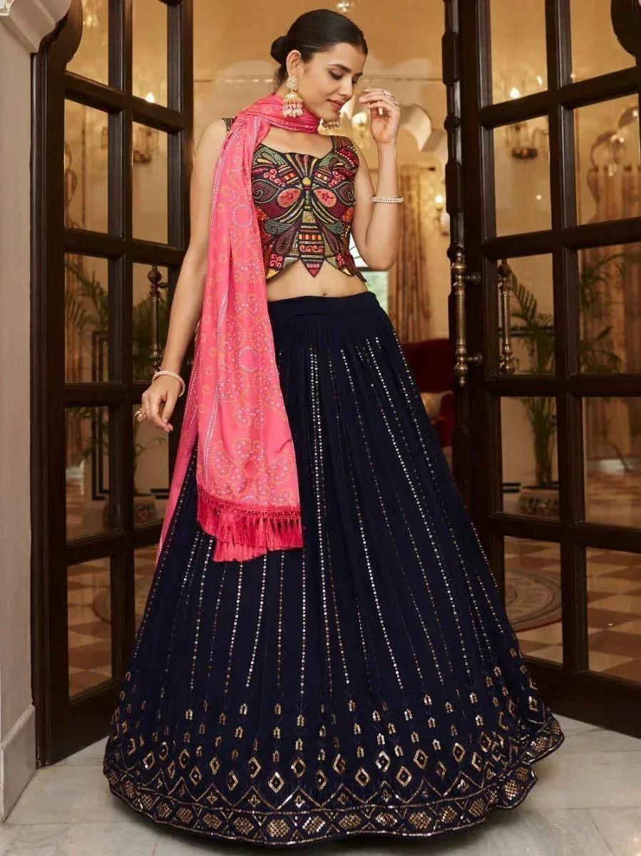 Woman in navy blue embroidered lehenga with pink dupatta, designer ethnic wear for festive occasions
