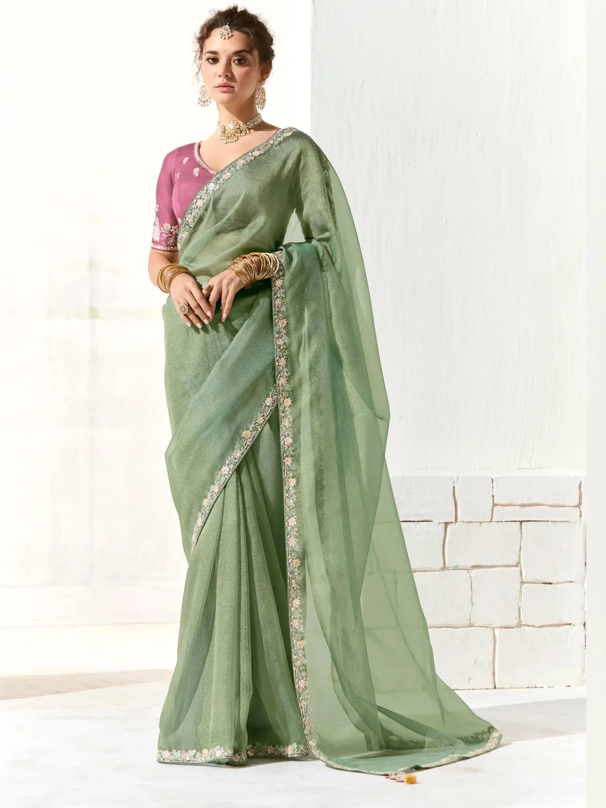 Elegant green saree with floral embroidery and pink blouse, styled with traditional jewelry for Indian ethnic wear.