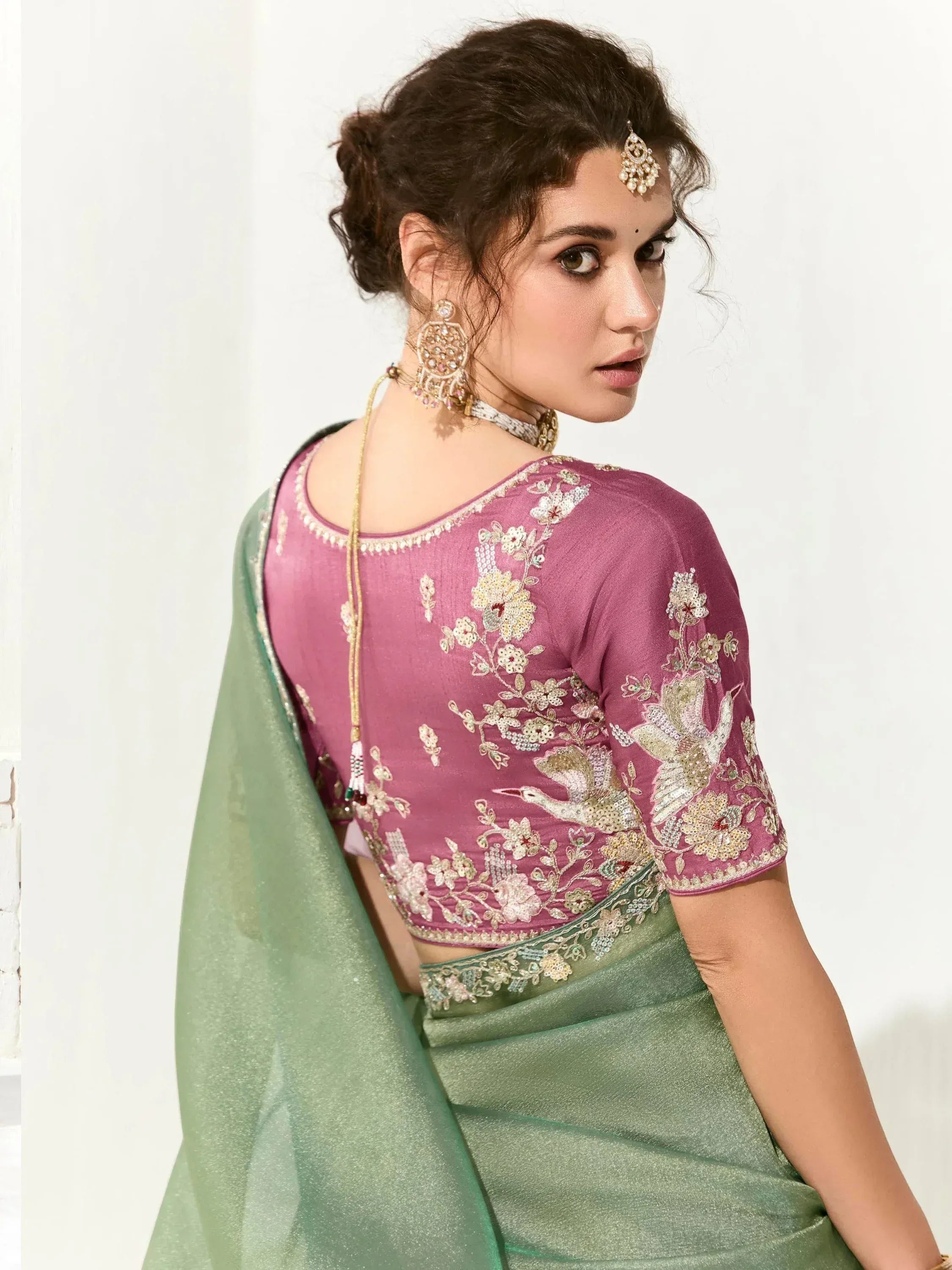 Pink embroidered blouse with floral and bird motifs paired with green saree, traditional Indian ethnic wear