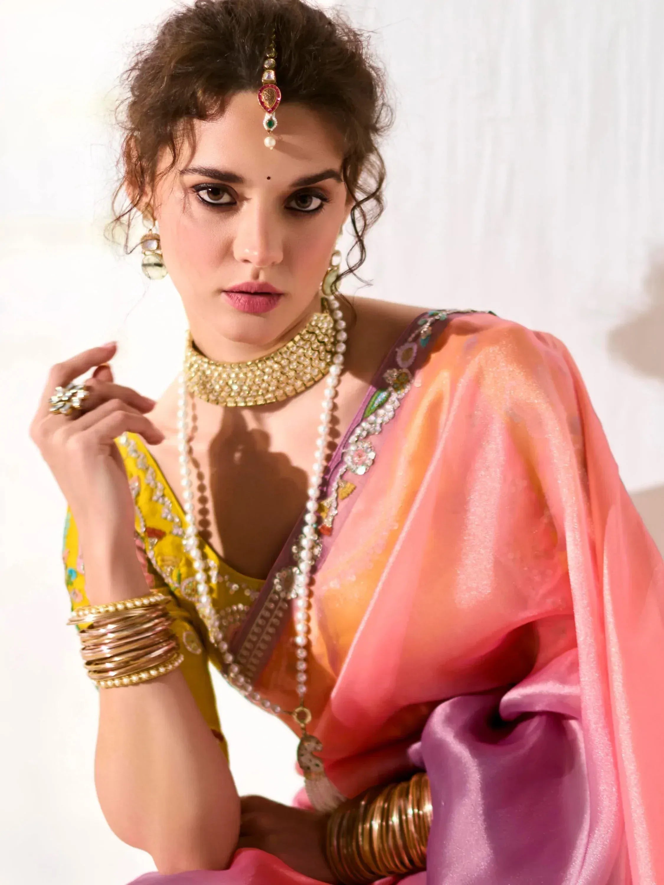Woman in vibrant Indian saree with gold jewelry, perfect for ethnic occasions and weddings.