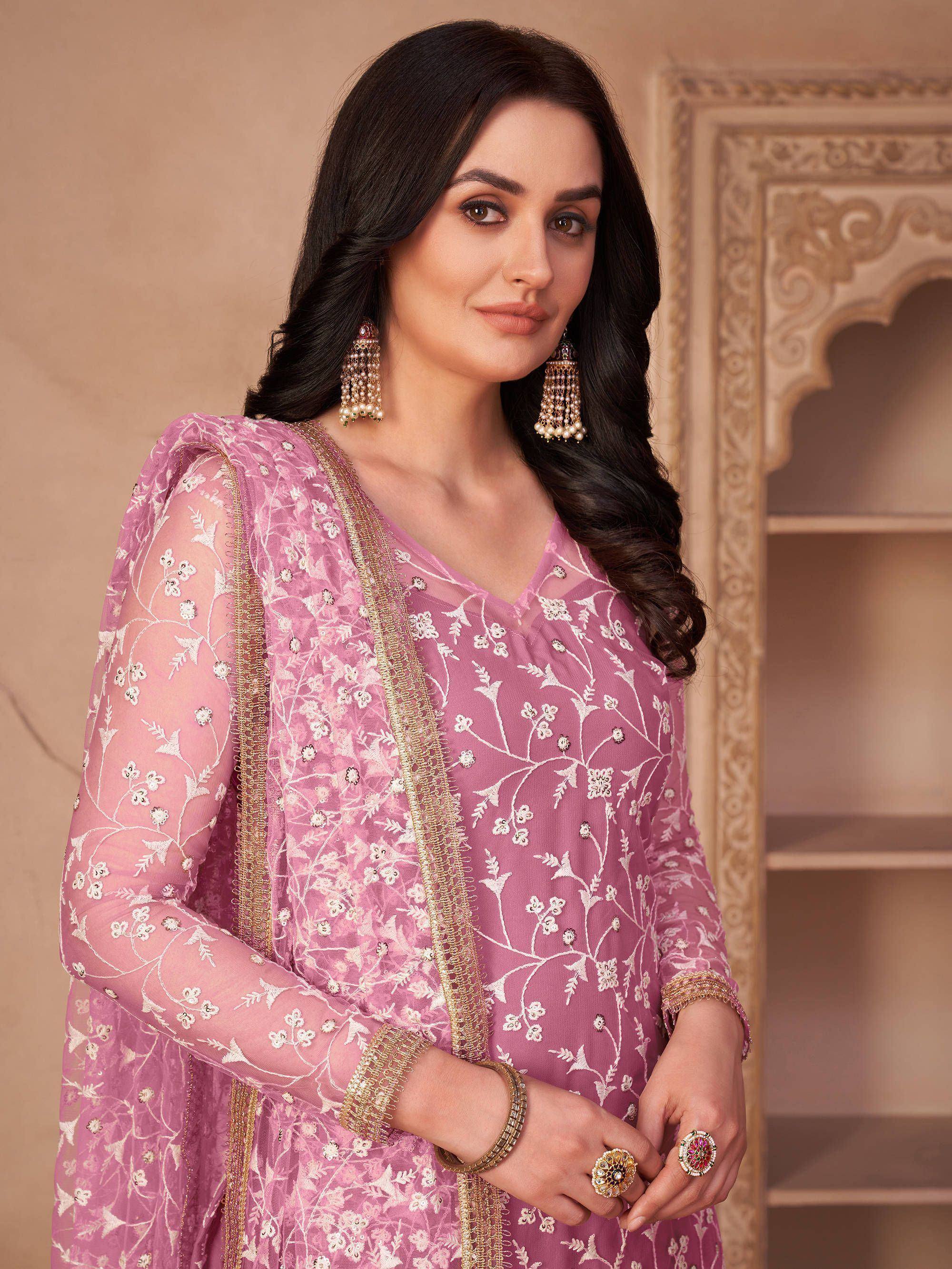 Pink embroidered salwar kameez with gold trim, floral design, and traditional jewelry for Indian ethnic wear