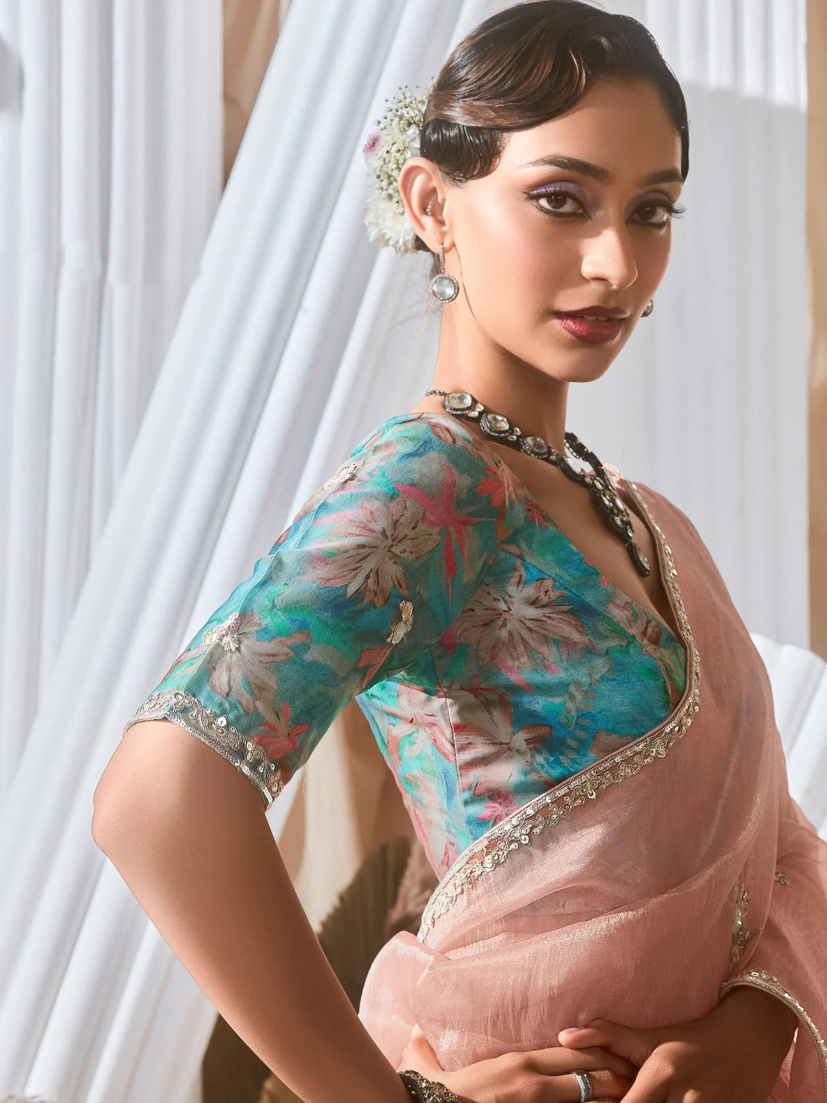 Woman in floral printed saree blouse with gold embroidery, styled for Indian ethnic wear