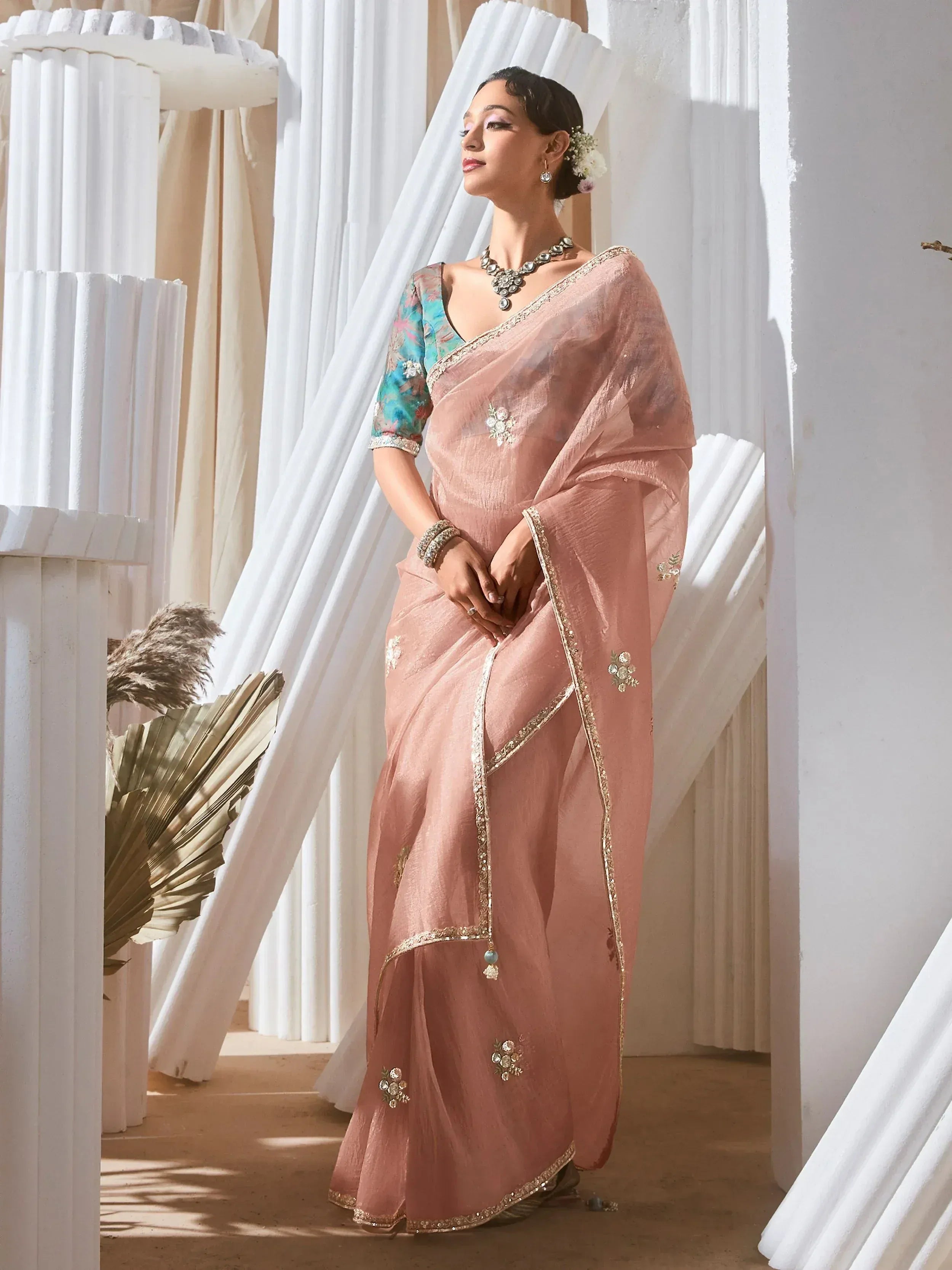 Elegant pink saree with floral embroidery and gold border, paired with a blue blouse for Indian ethnic wear
