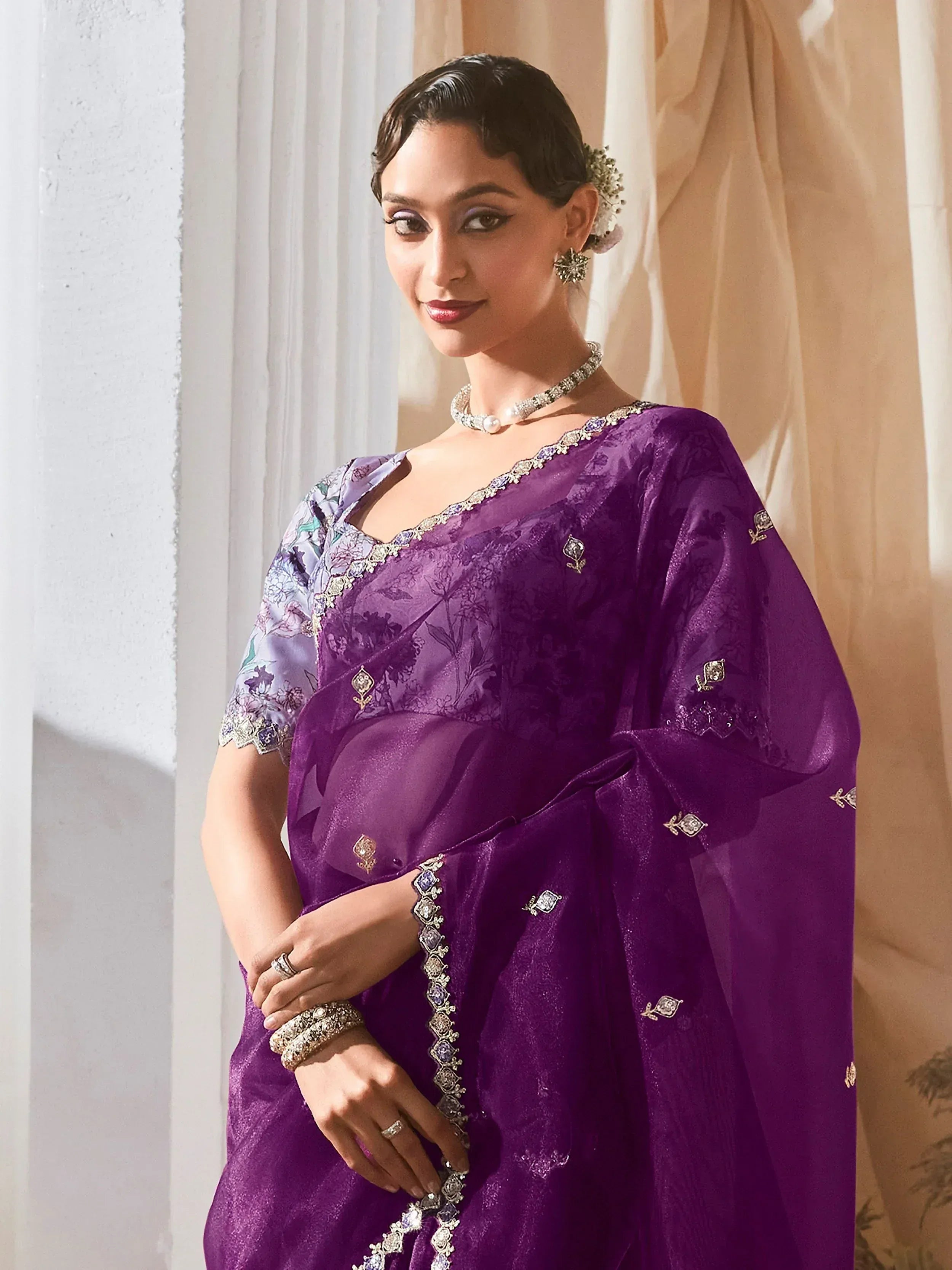 Elegant purple designer saree with floral embroidery and embellished border, perfect for Indian ethnic occasions.