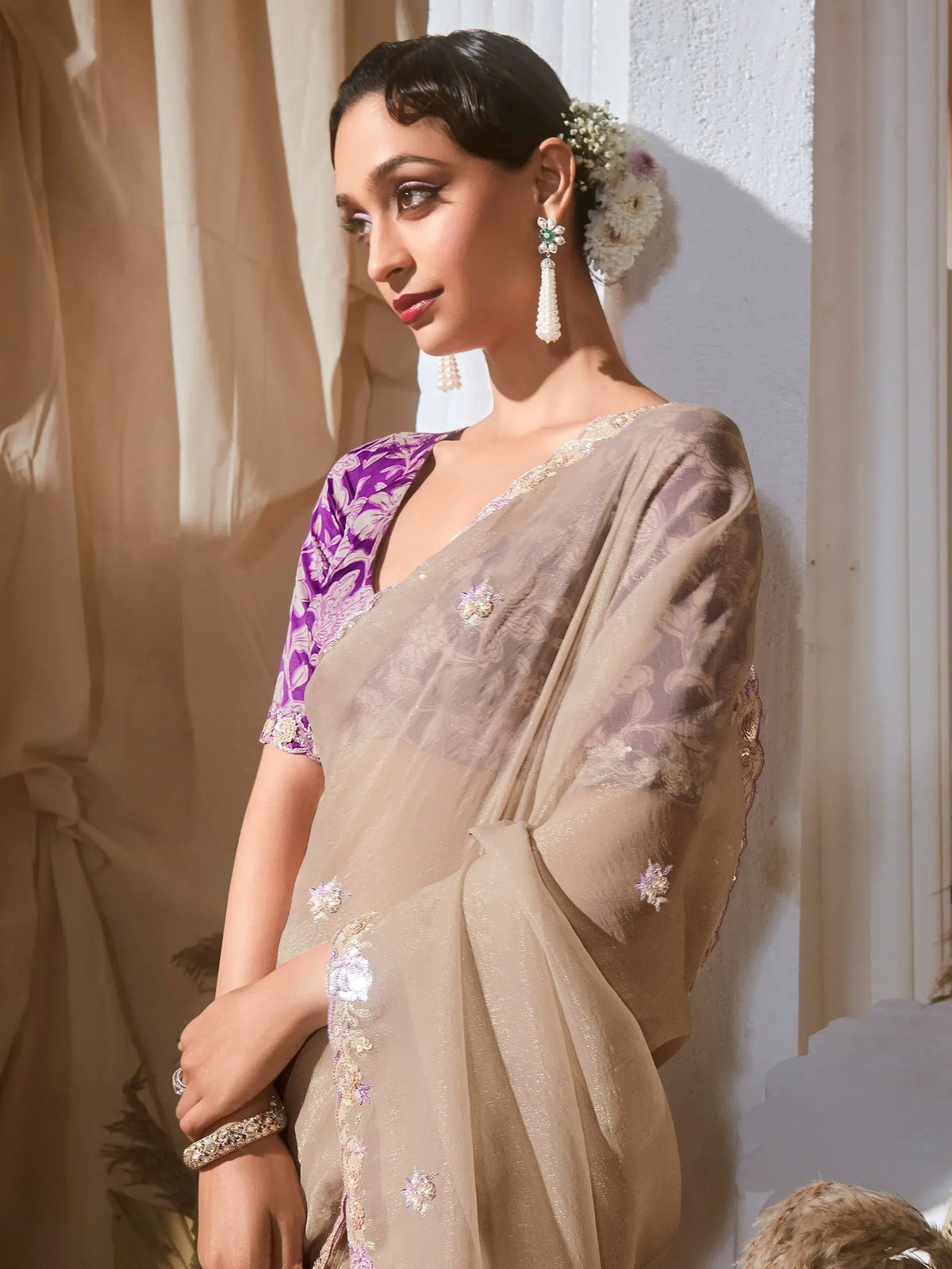 Elegant beige saree with purple floral blouse, perfect for Indian ethnic occasions and weddings.
