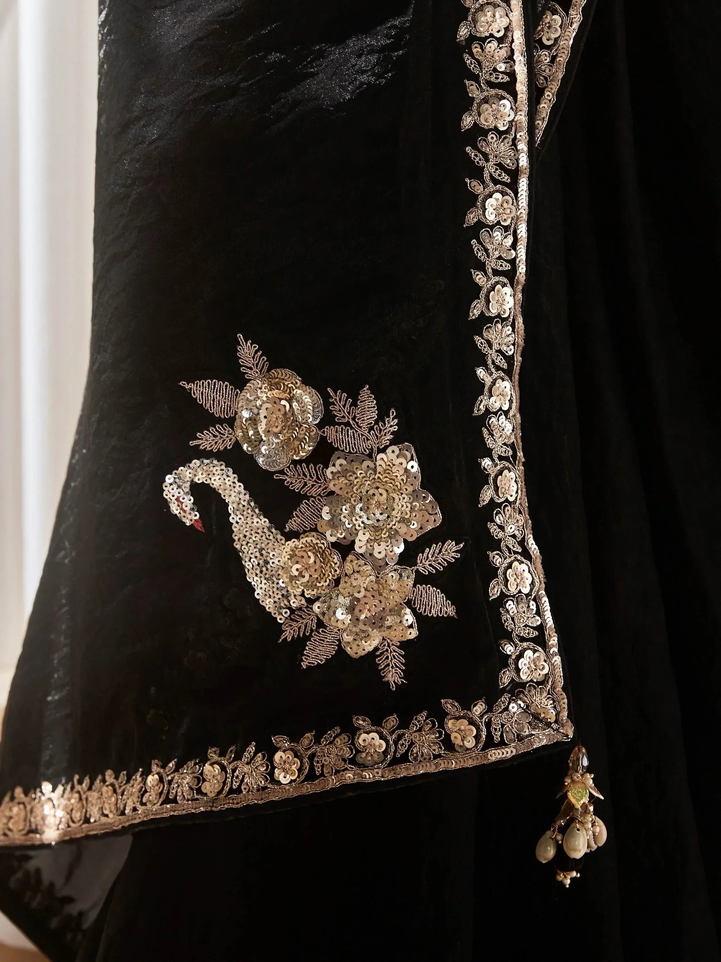 Black velvet ethnic gown with gold sequin peacock and floral embroidery, perfect for Indian occasions.