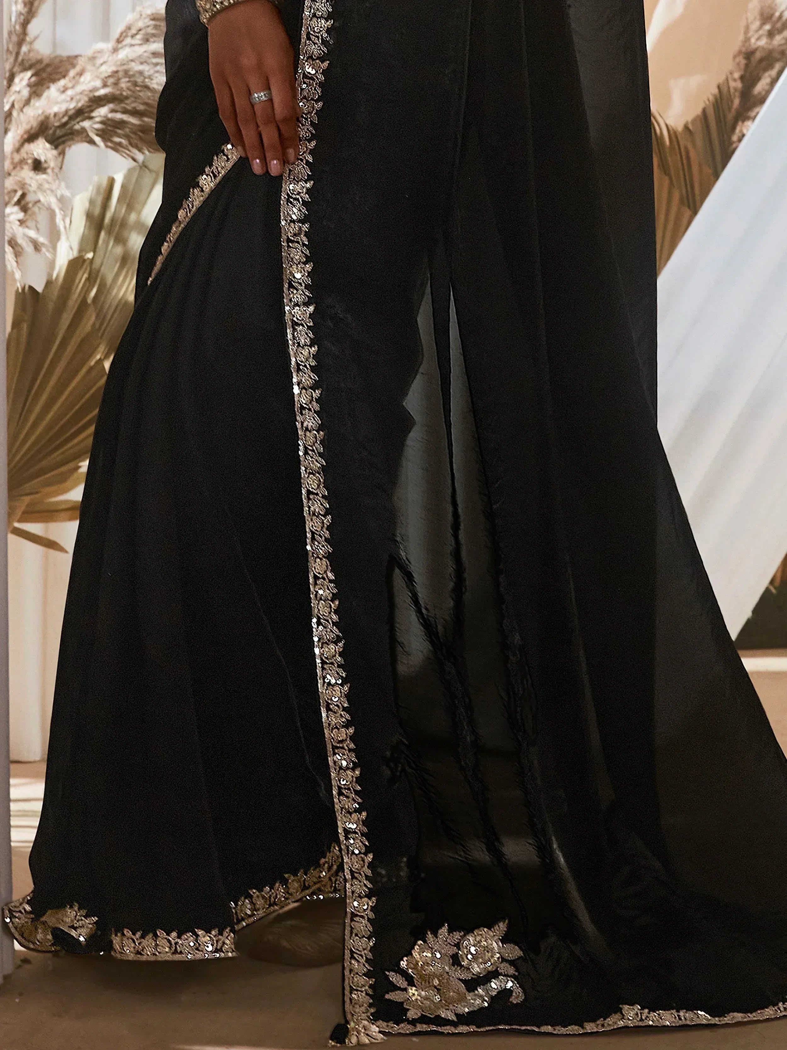 Black ethnic gown with gold embroidery and sequin detailing, perfect for Indian occasions