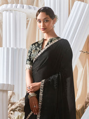 Woman wearing a black saree with a floral blouse