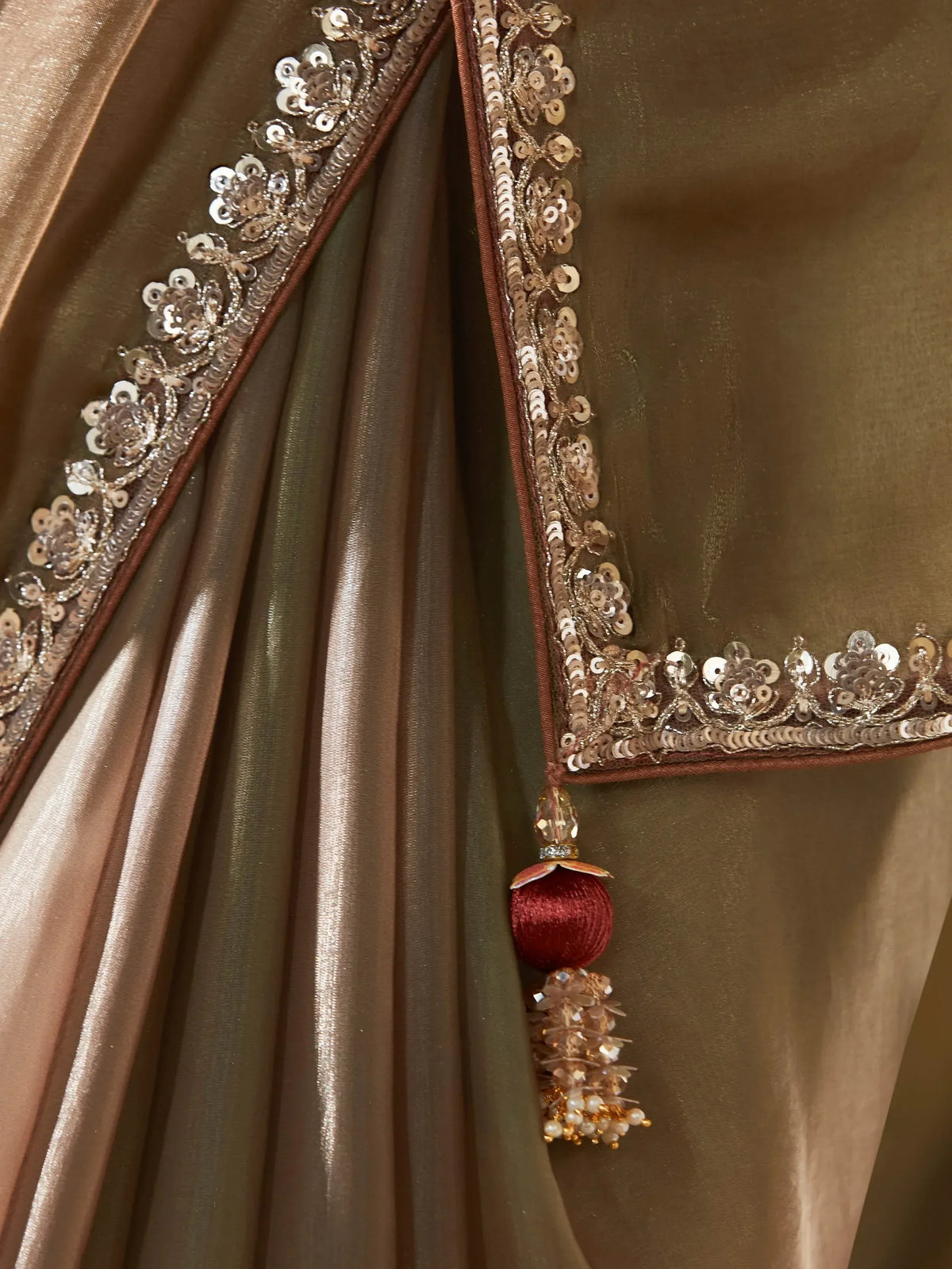 Luxury ethnic saree with intricate sequin embroidery and tassel detailing, perfect for festive occasions.