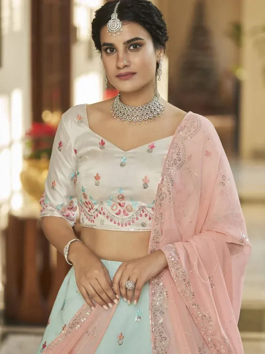 Elegant Indian lehenga choli with floral embroidery, pink dupatta, and traditional jewelry for festive occasions