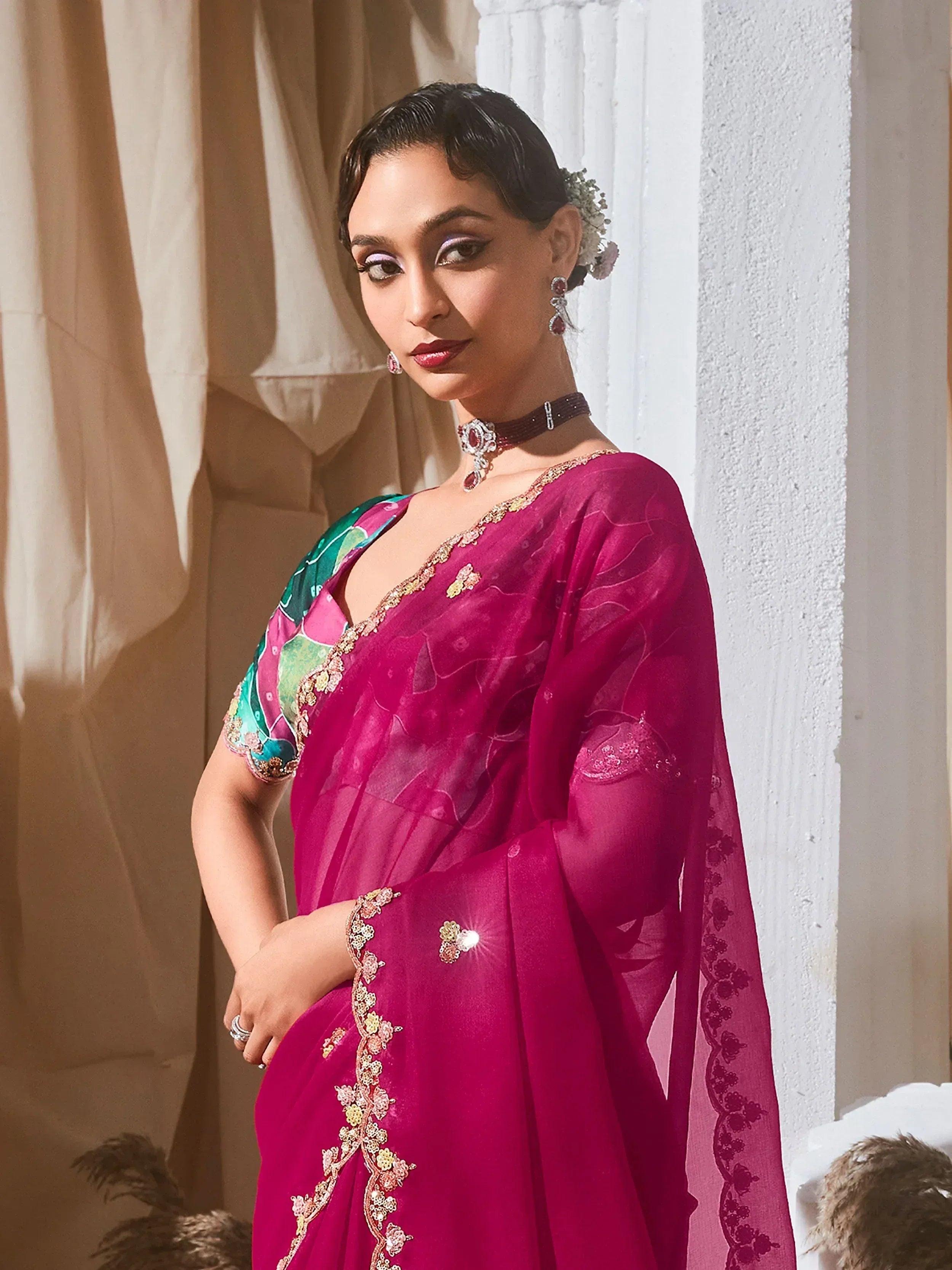 Woman in vibrant pink embroidered saree with floral blouse, perfect for Indian ethnic wear occasions
