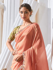 Woman wearing a peach saree with green blouse