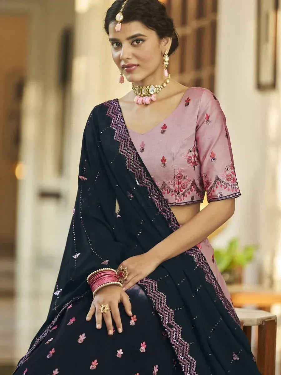Pink and navy blue embroidered lehenga choli with floral motifs and traditional jewelry