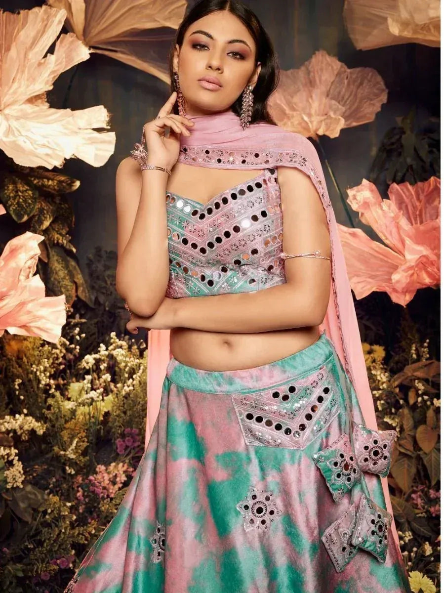 Pink and teal mirror-work lehenga choli with floral backdrop, ethnic Indian wear