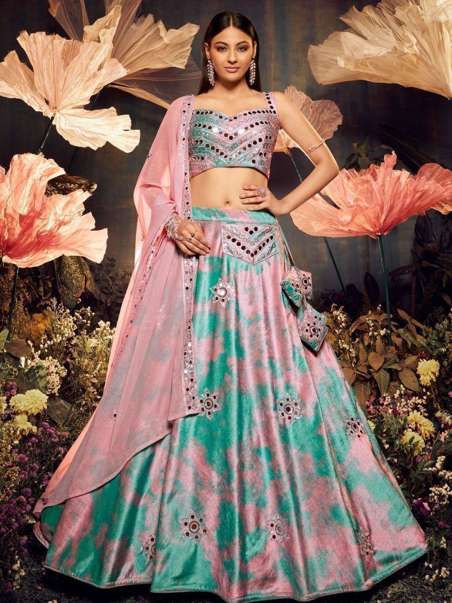 Pink and teal designer lehenga choli with mirror work, floral backdrop, ethnic wear