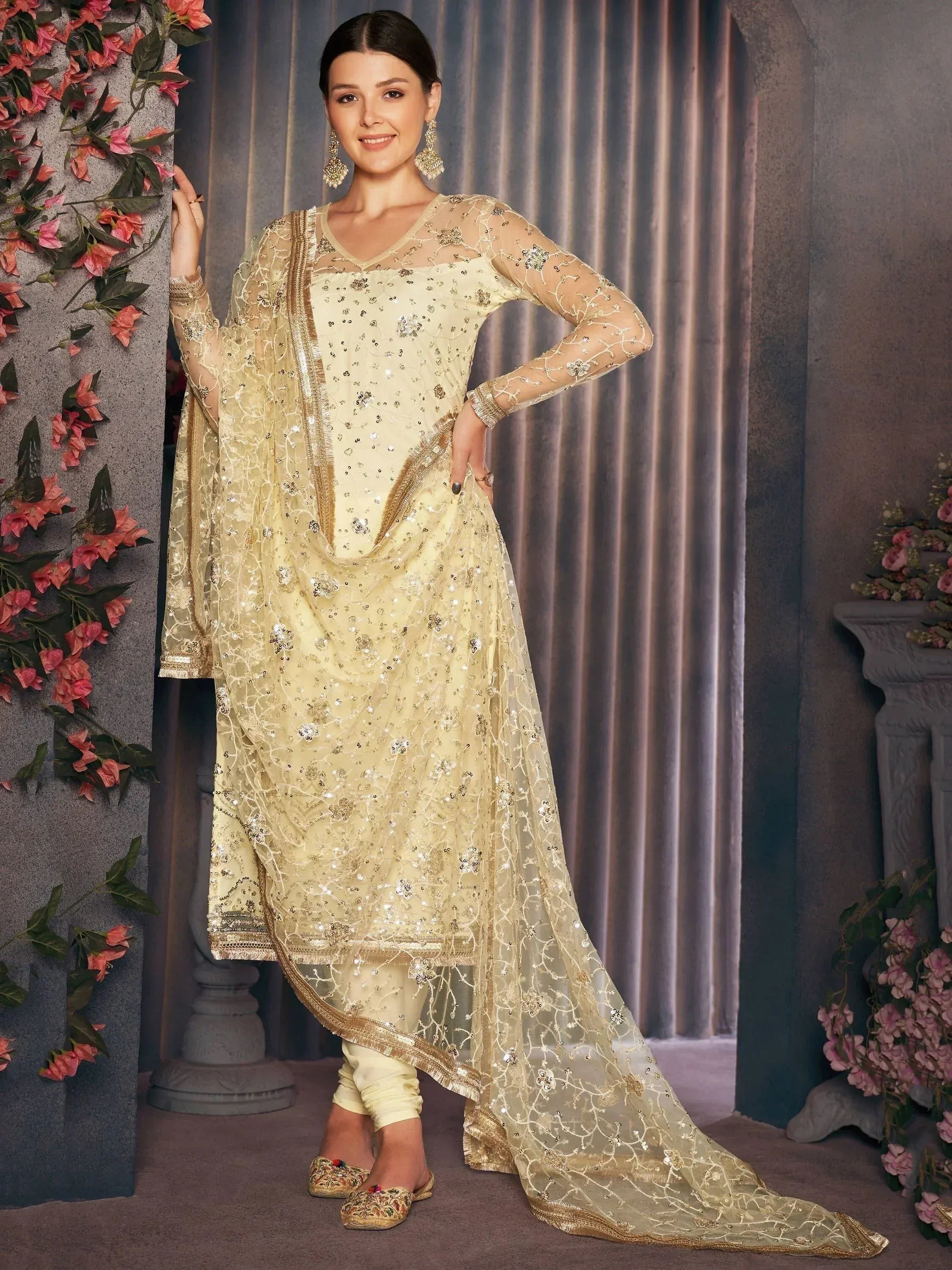 Elegant cream salwar kameez with gold embroidery, sheer dupatta, and embellished churidar for festive occasions