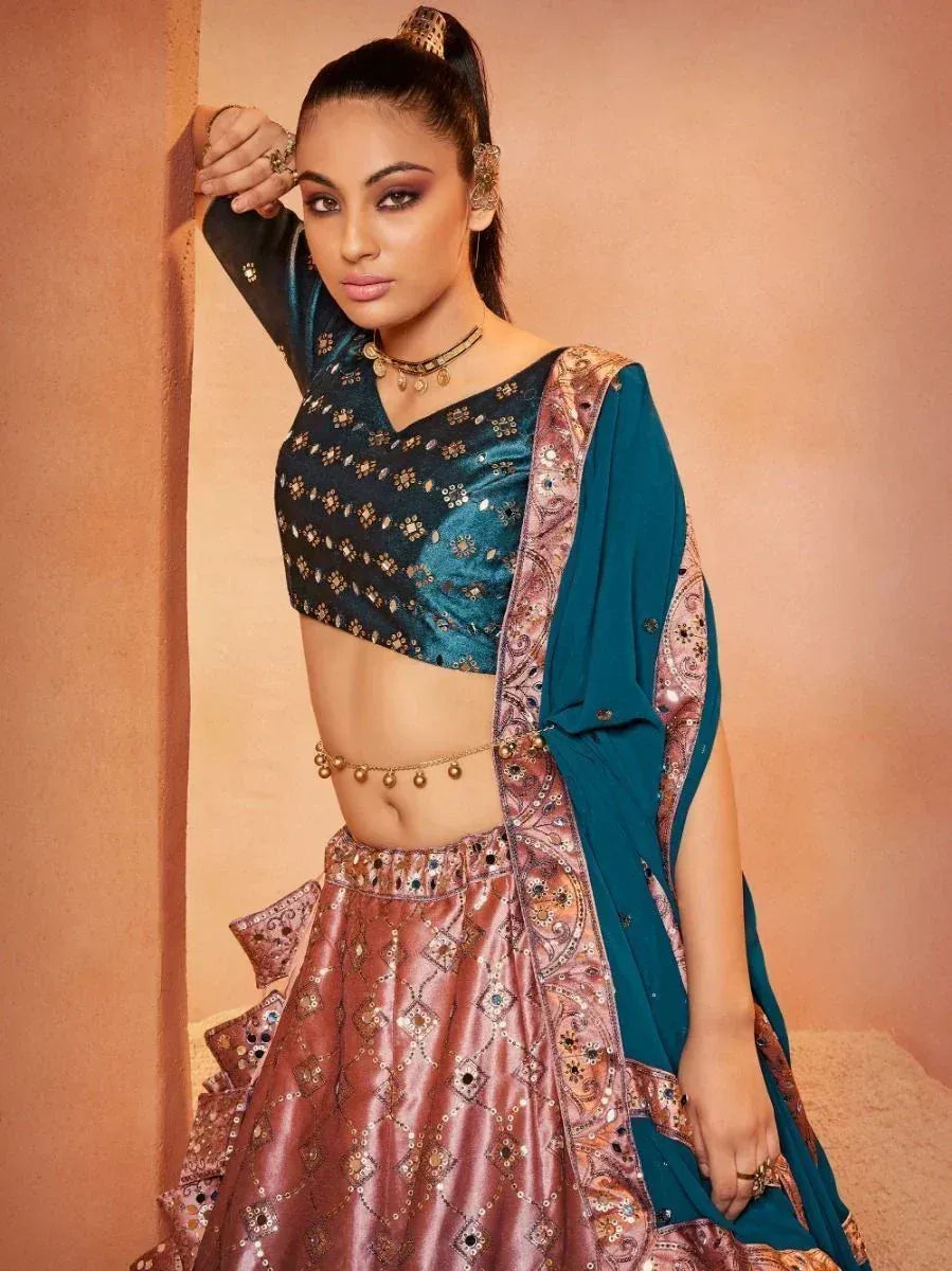 Teal and rose gold designer lehenga choli with intricate embroidery and sequins, perfect for Indian ethnic wear.
