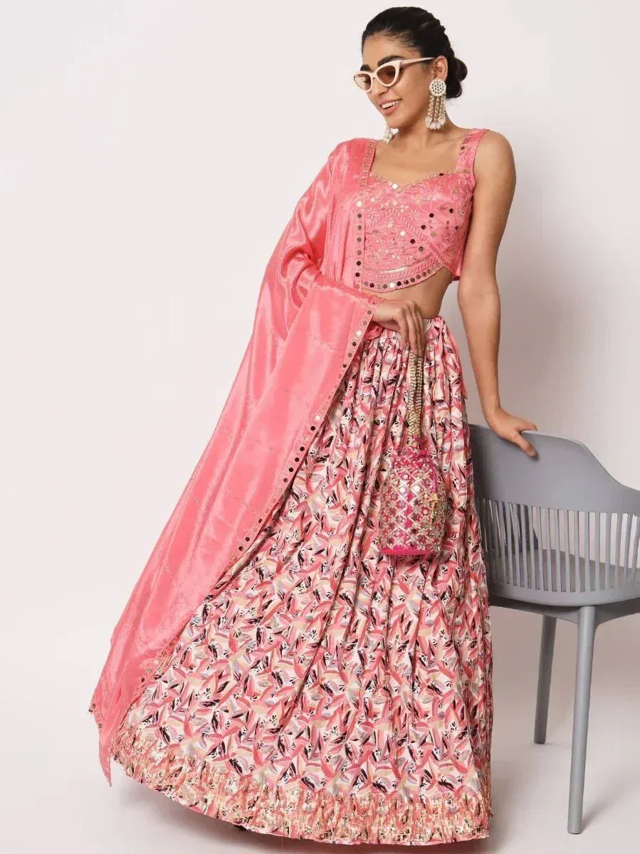 Pink embroidered lehenga choli with floral skirt and matching dupatta, styled with statement earrings