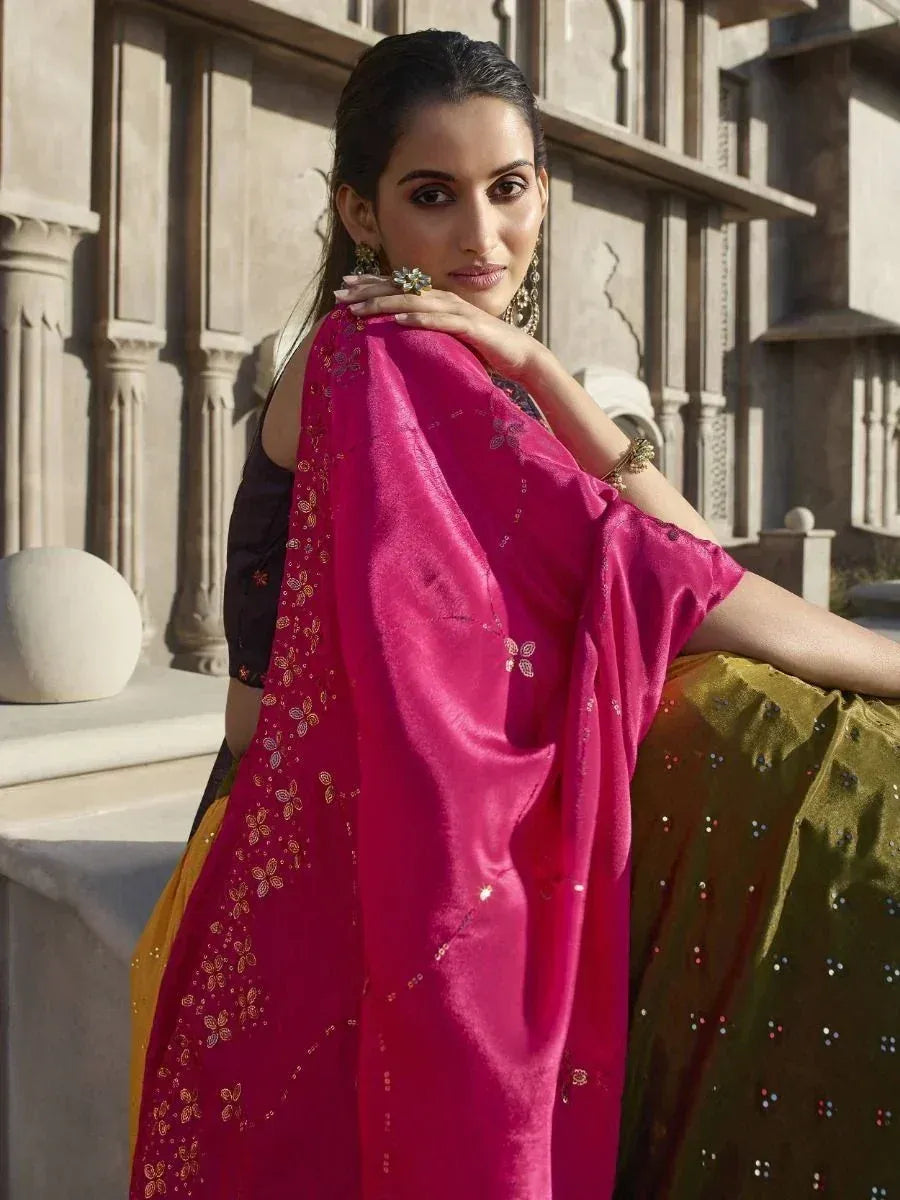 Woman in vibrant pink and green ethnic saree with gold embroidery, styled for Indian occasions