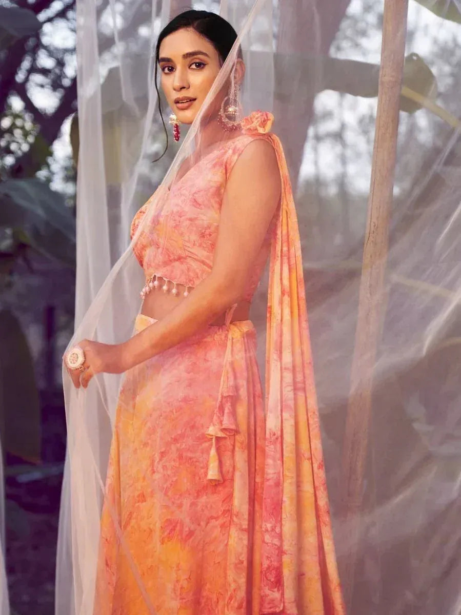 Woman in peach orange tie-dye lehenga choli with sheer dupatta, perfect for Indian ethnic occasions
