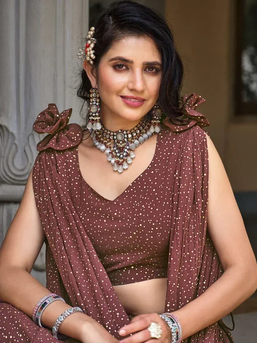 Woman in maroon polka dot lehenga choli with floral shoulder details and traditional jewelry