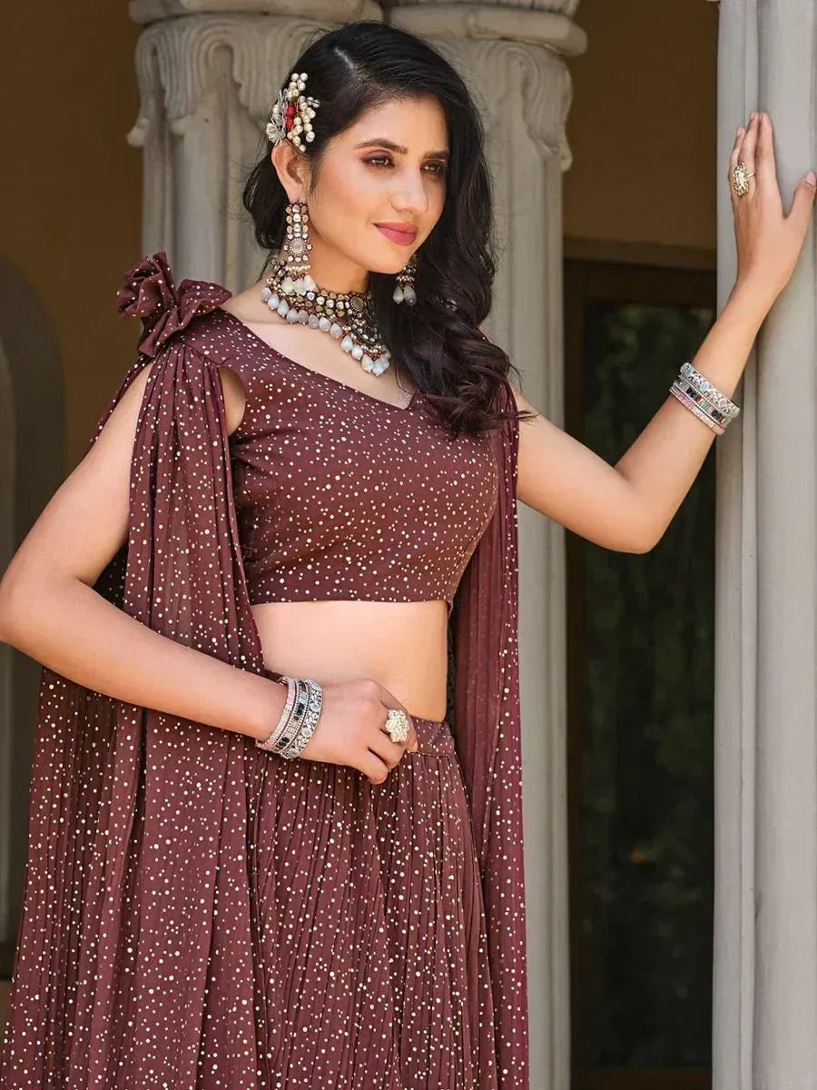 Maroon polka dot lehenga choli with floral hair accessory and traditional jewelry