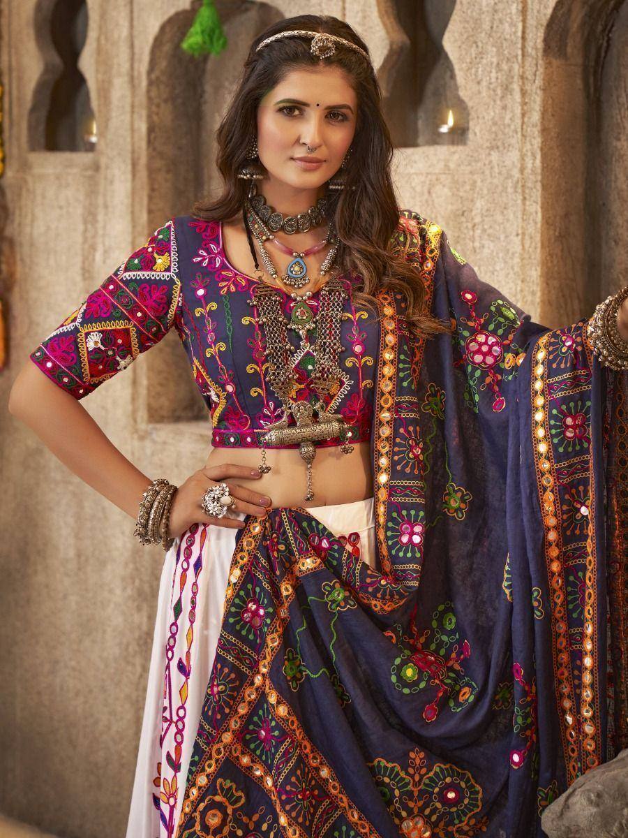 Woman in colorful embroidered Indian lehenga choli with mirror work and traditional jewelry