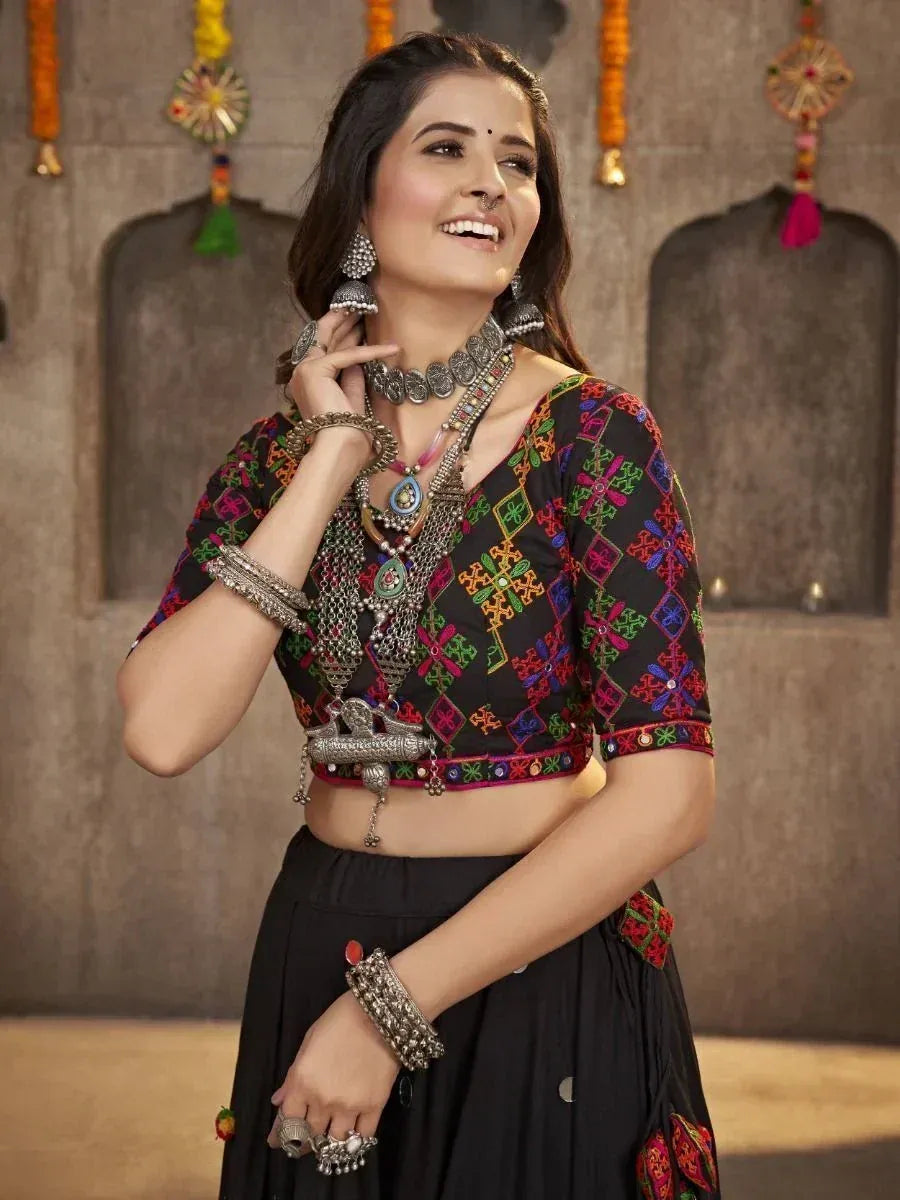 Black embroidered lehenga choli with colorful mirror work and traditional silver jewelry